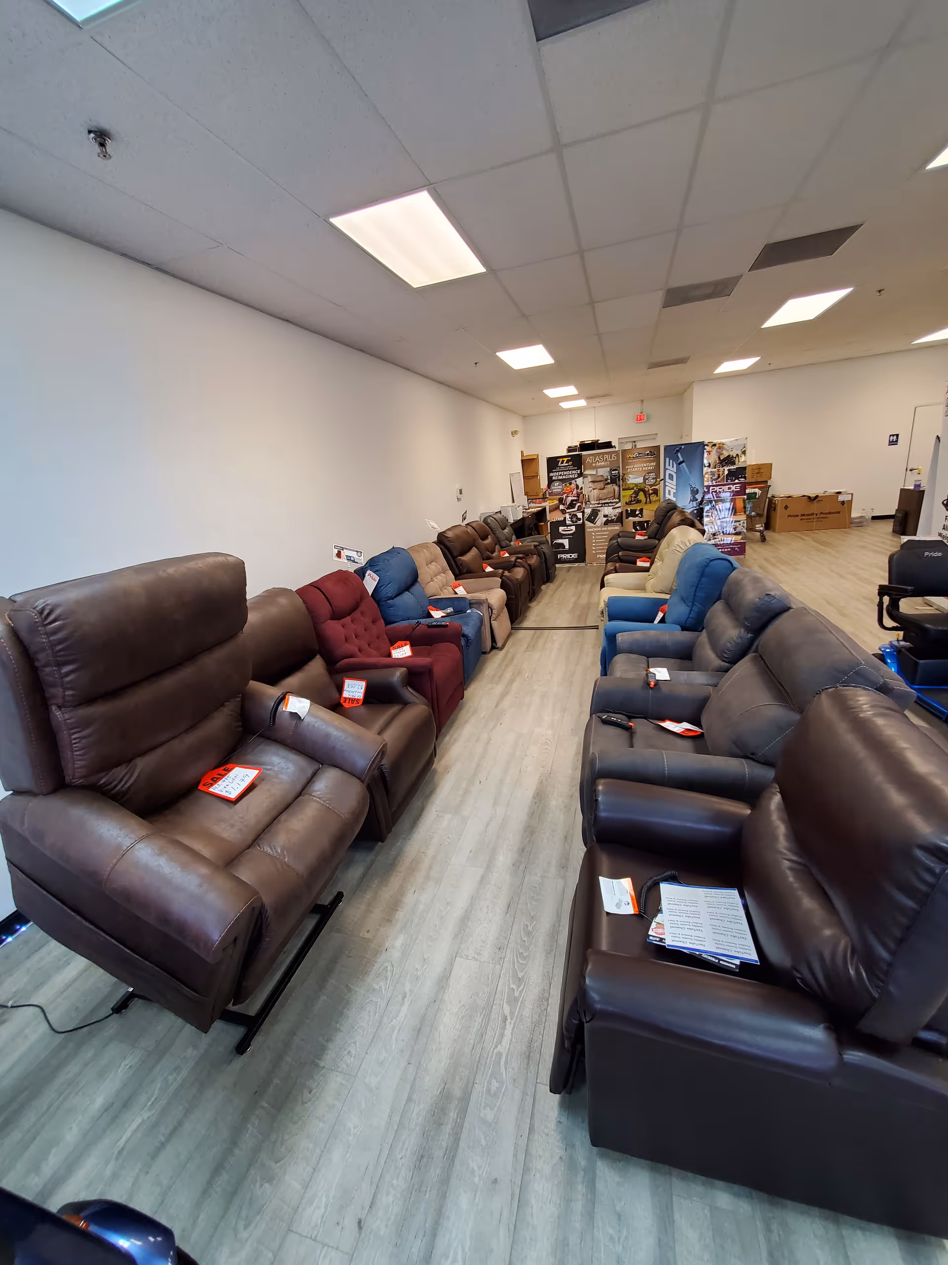 Long row of brown and blue recliner chairs arranged in a showroom hallway.