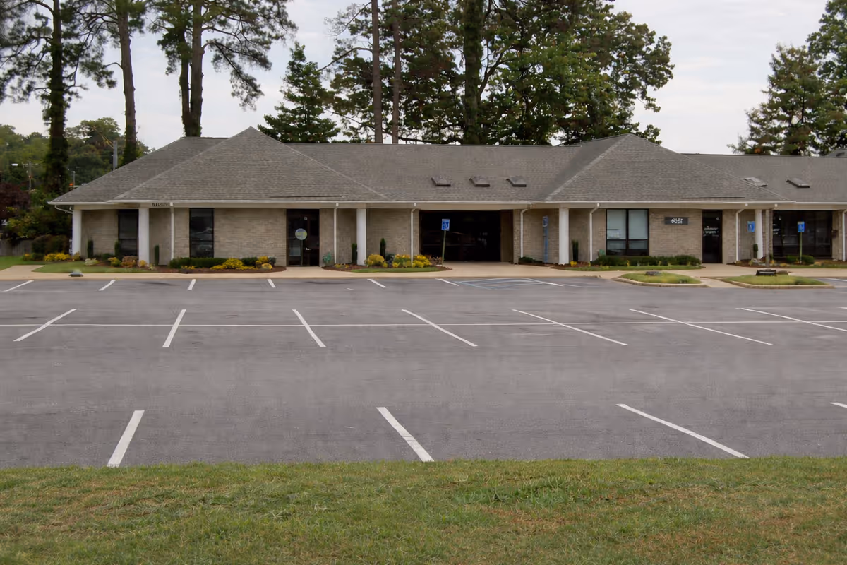 Front of Better Tomorrow Home Health Care building with parking lot and pine trees in background