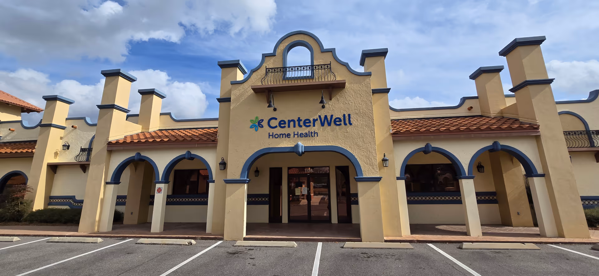 Front view of CenterWell Home Health building with arches and a parking lot.