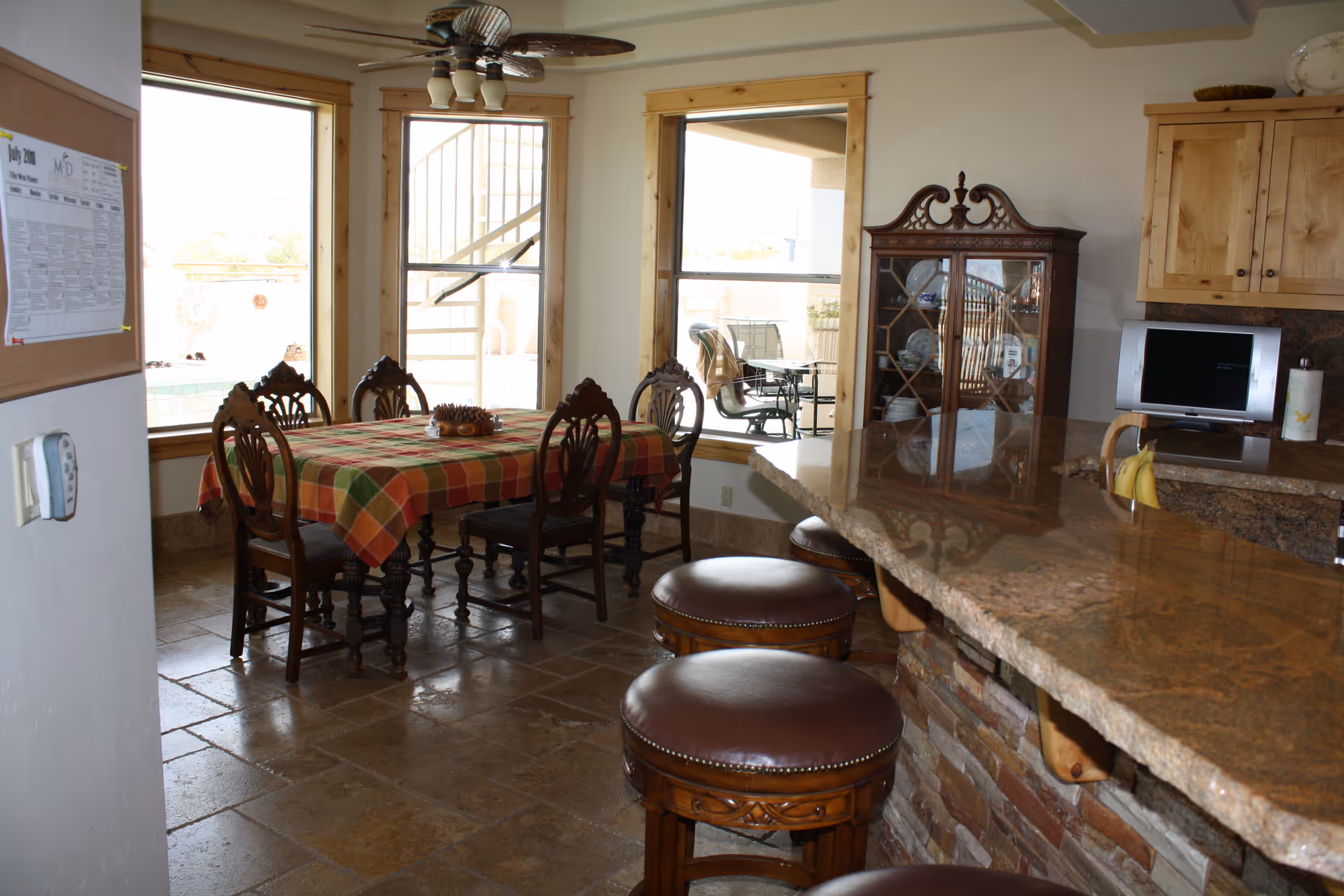 Interior dining room with a table, chairs, and a granite bar in a senior living facility.