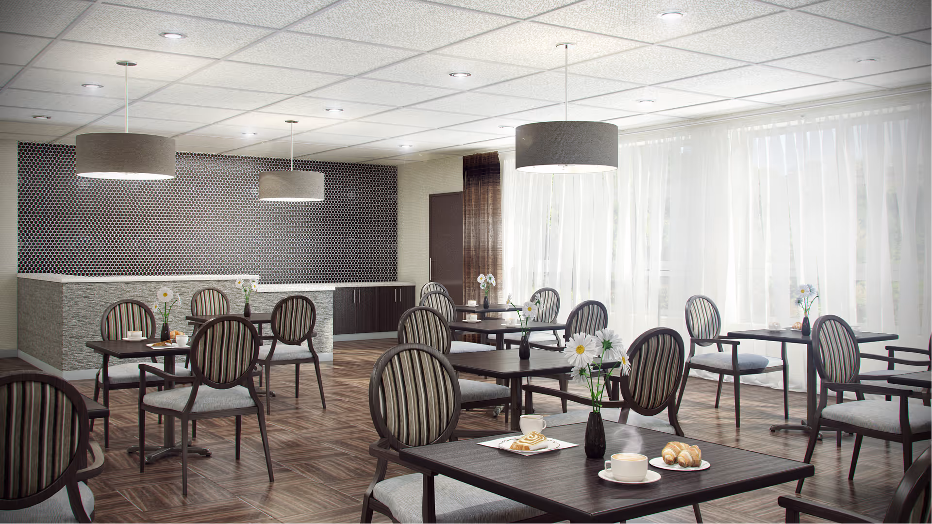 A bright dining room with multiple dark wood tables and striped cushioned chairs. Each table has a small vase with white flowers and some have plates with pastries and cups. Large windows with sheer white curtains allow natural light to fill the room. Modern pendant lights hang from the ceiling, and a textured wall with a geometric pattern is visible in the background.