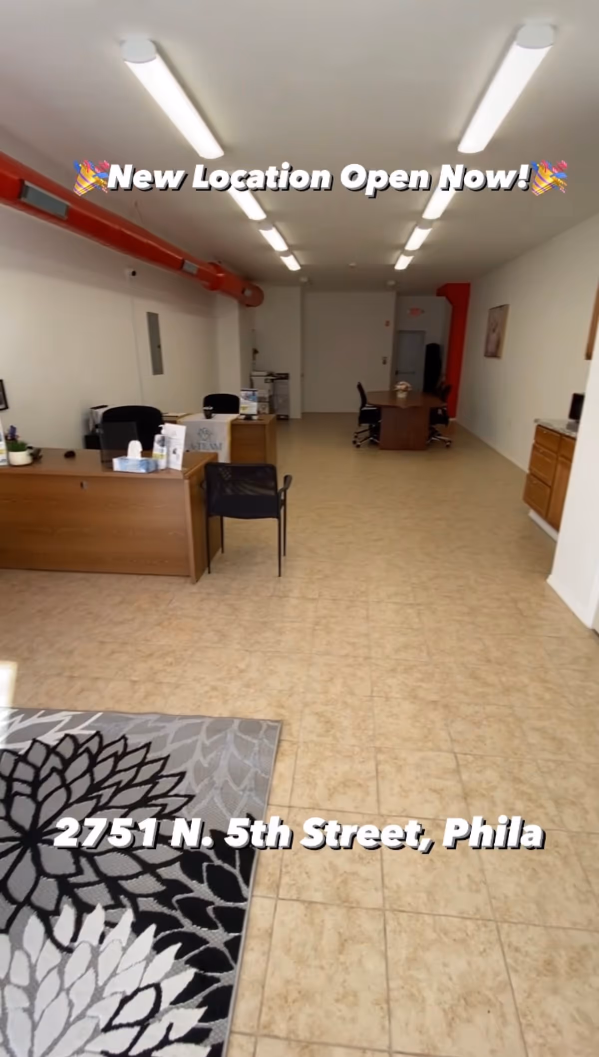 Long, well-lit lobby with desks, chairs, and a hallway toward back offices.