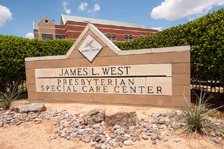 Front view of a stone sign for James L. West Presbyterian Special Care Center with landscaping.
