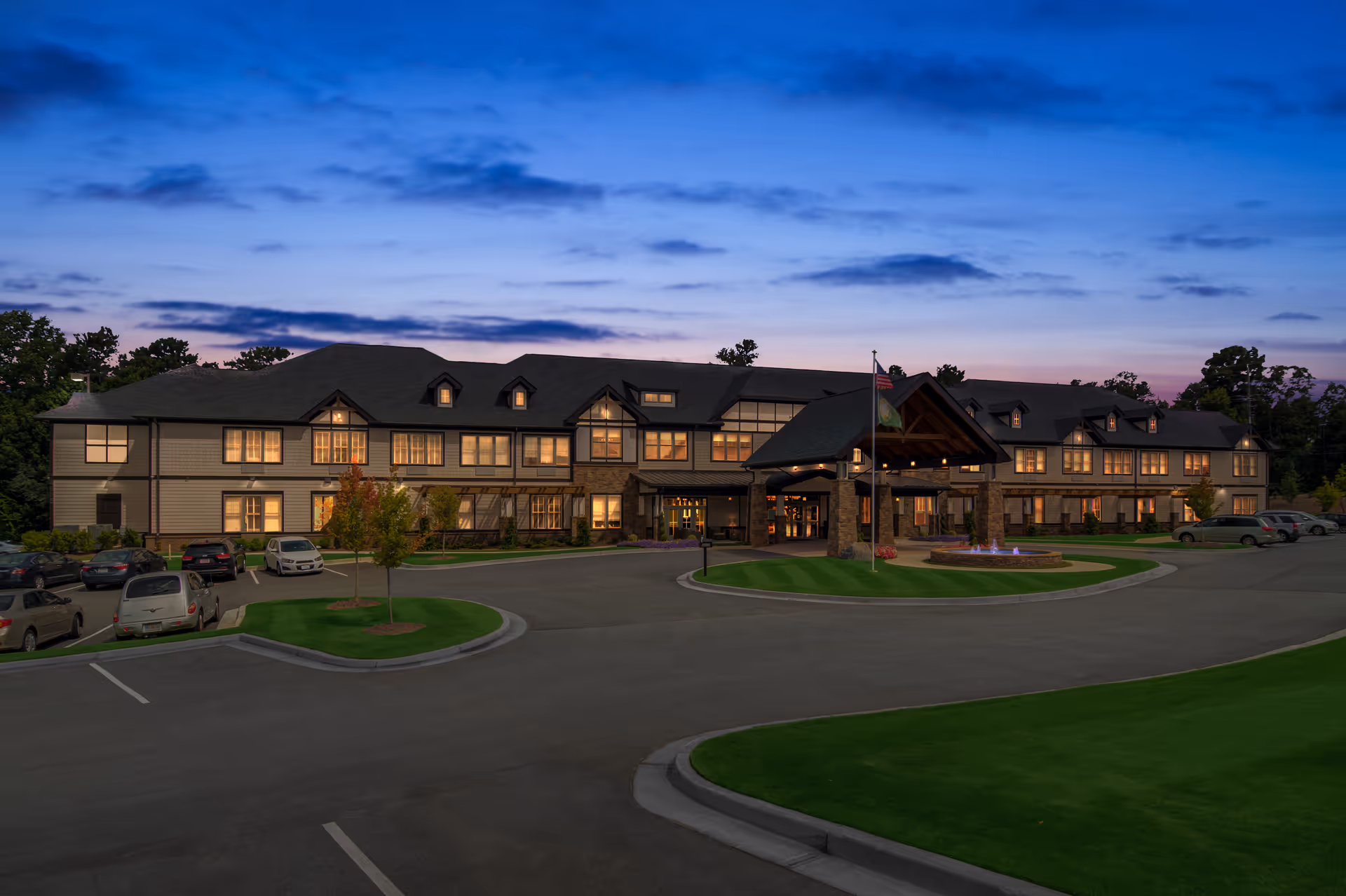 Exterior view of Oaks at Douglasville senior living campus with illuminated entrance at dusk