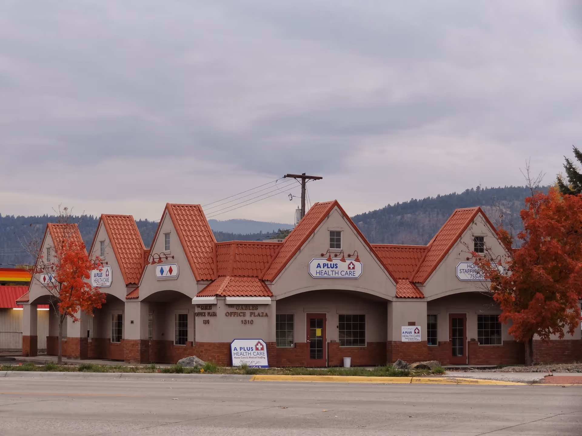 Exterior view of a single-story A-Plus Health Care building with red-tiled roof.