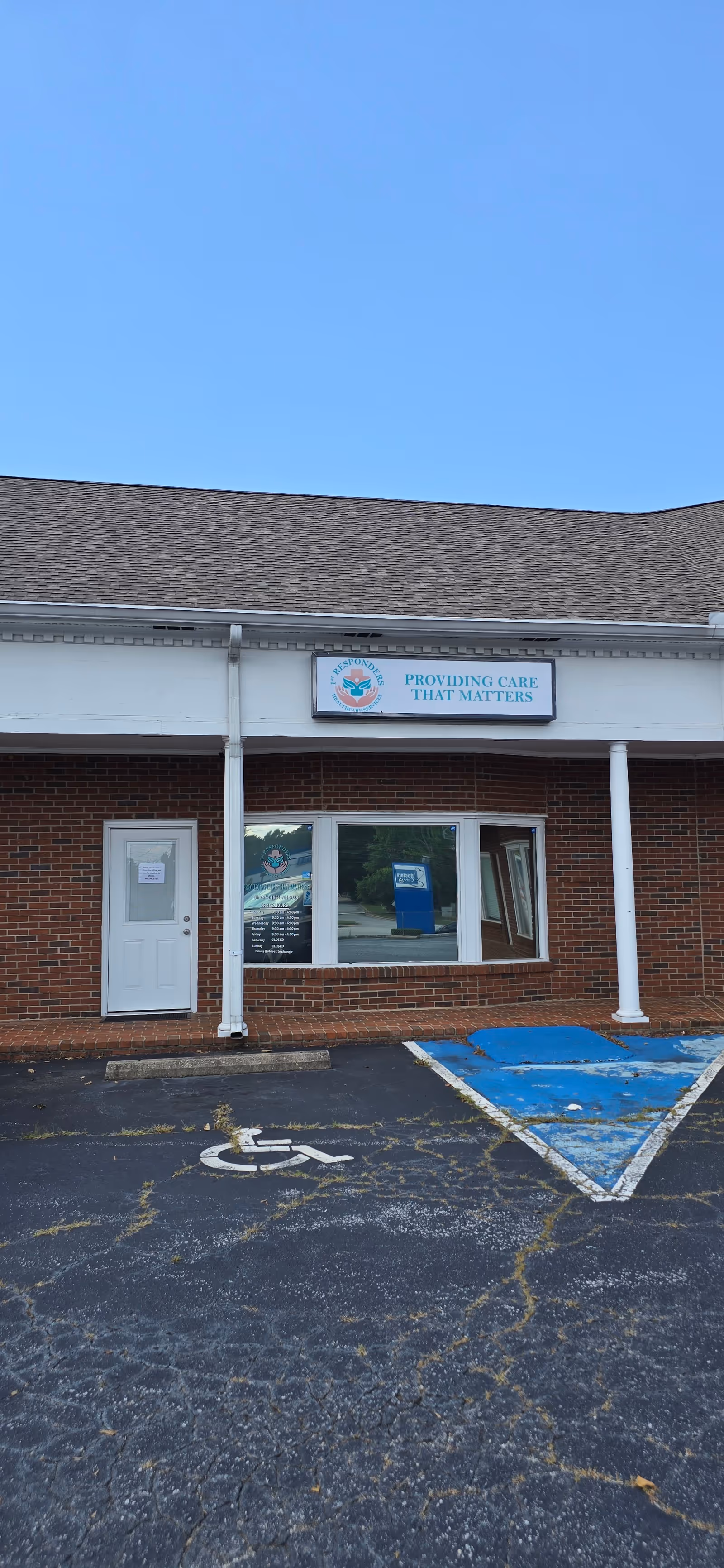 Brick storefront with sign Providing Care That Matters and blue handicapped parking.
