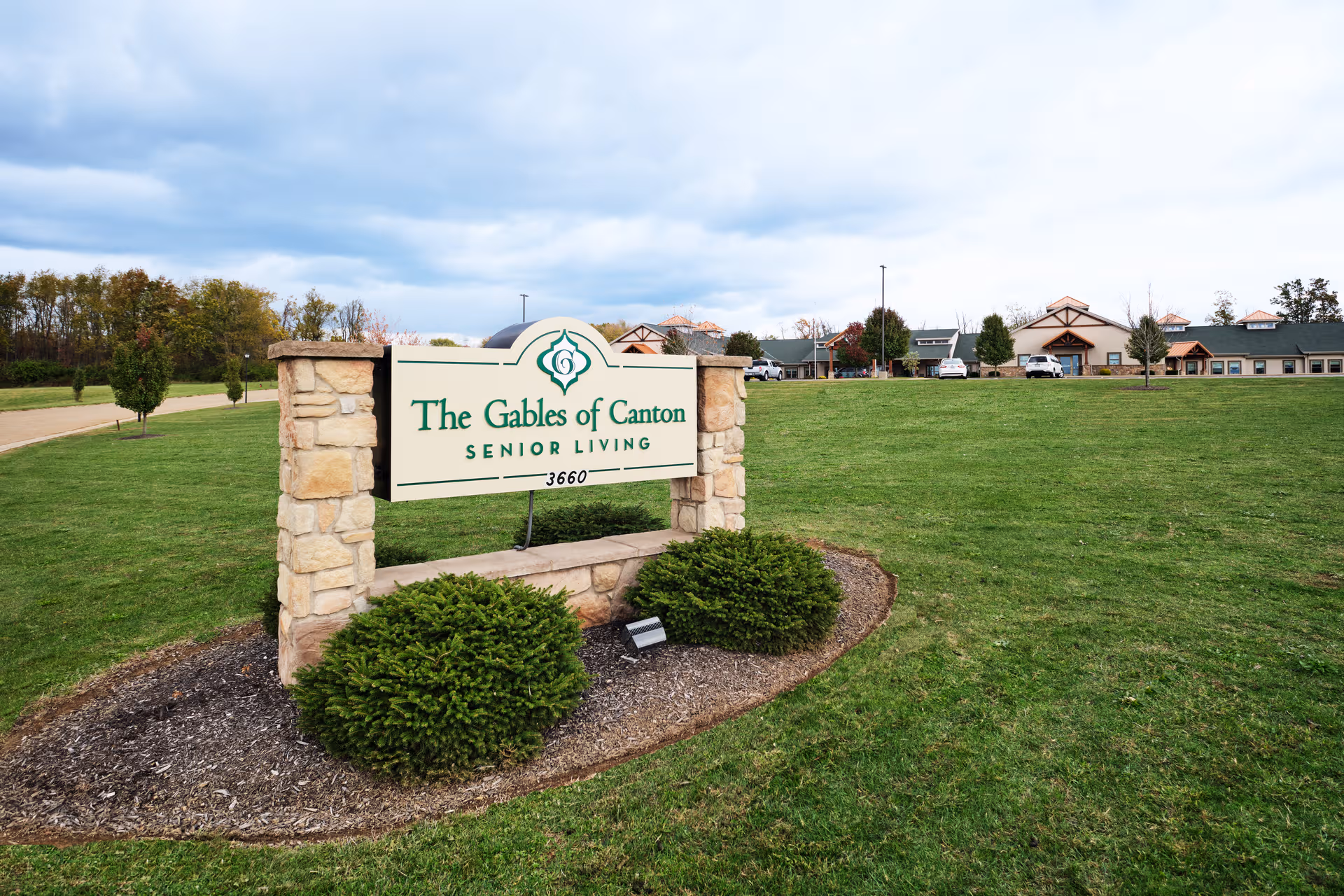 The Gables of Canton sign on a grassy front yard with a building in distance