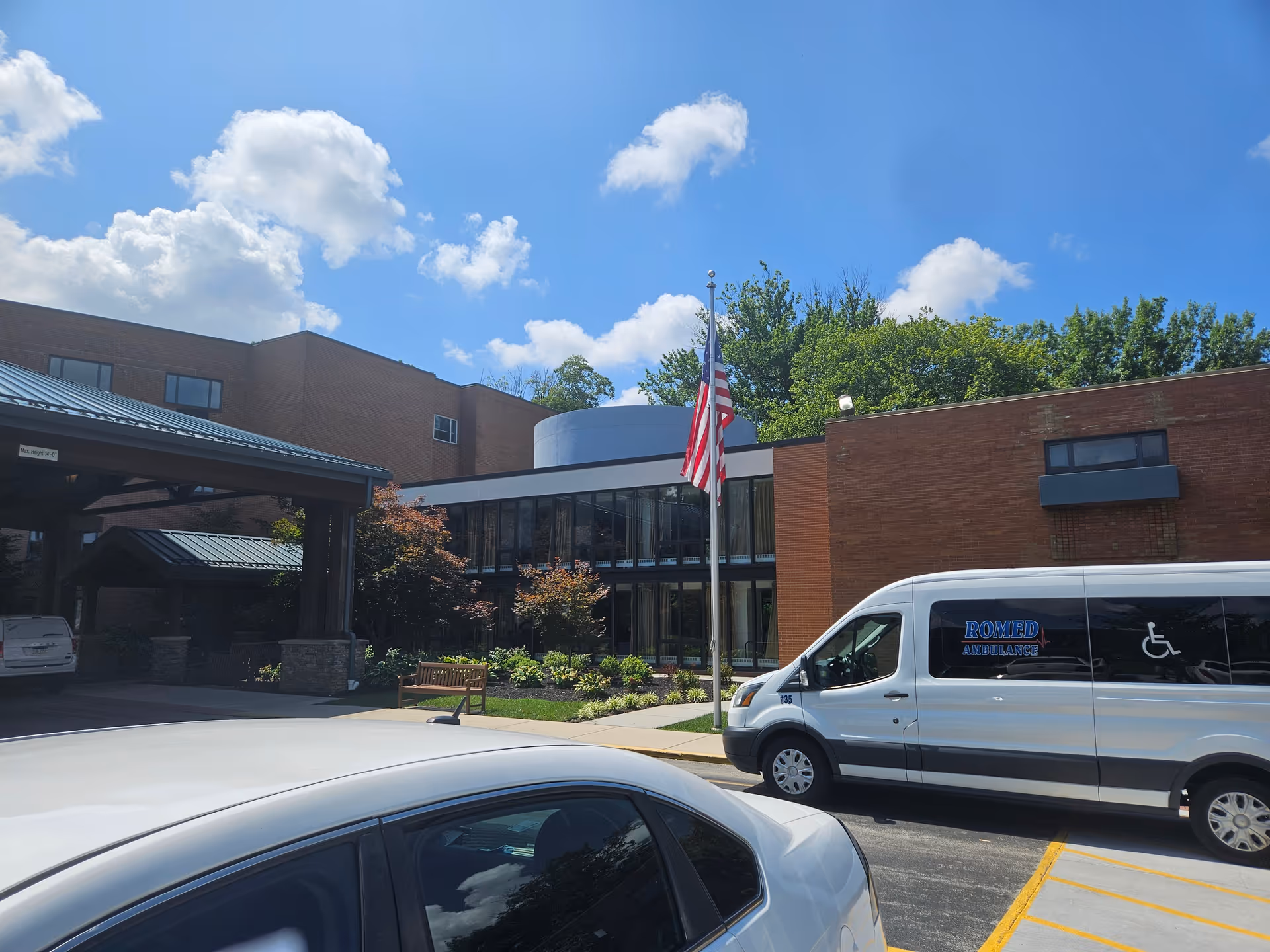 Saunders House exterior with flag, ambulance van, and front entrance.