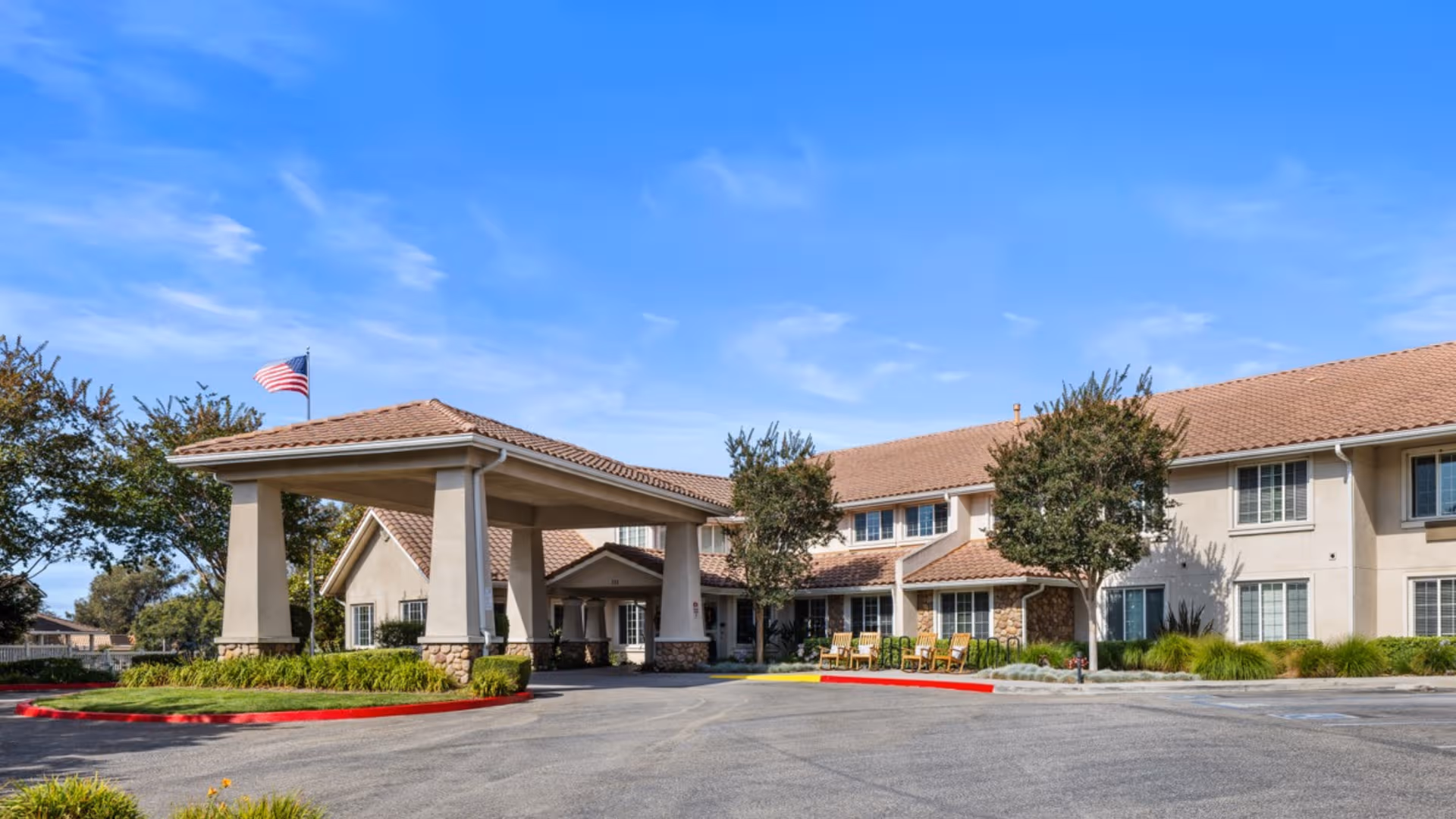 Exterior view of The Palms at Bonaventure with porte-cochere entrance and flag.