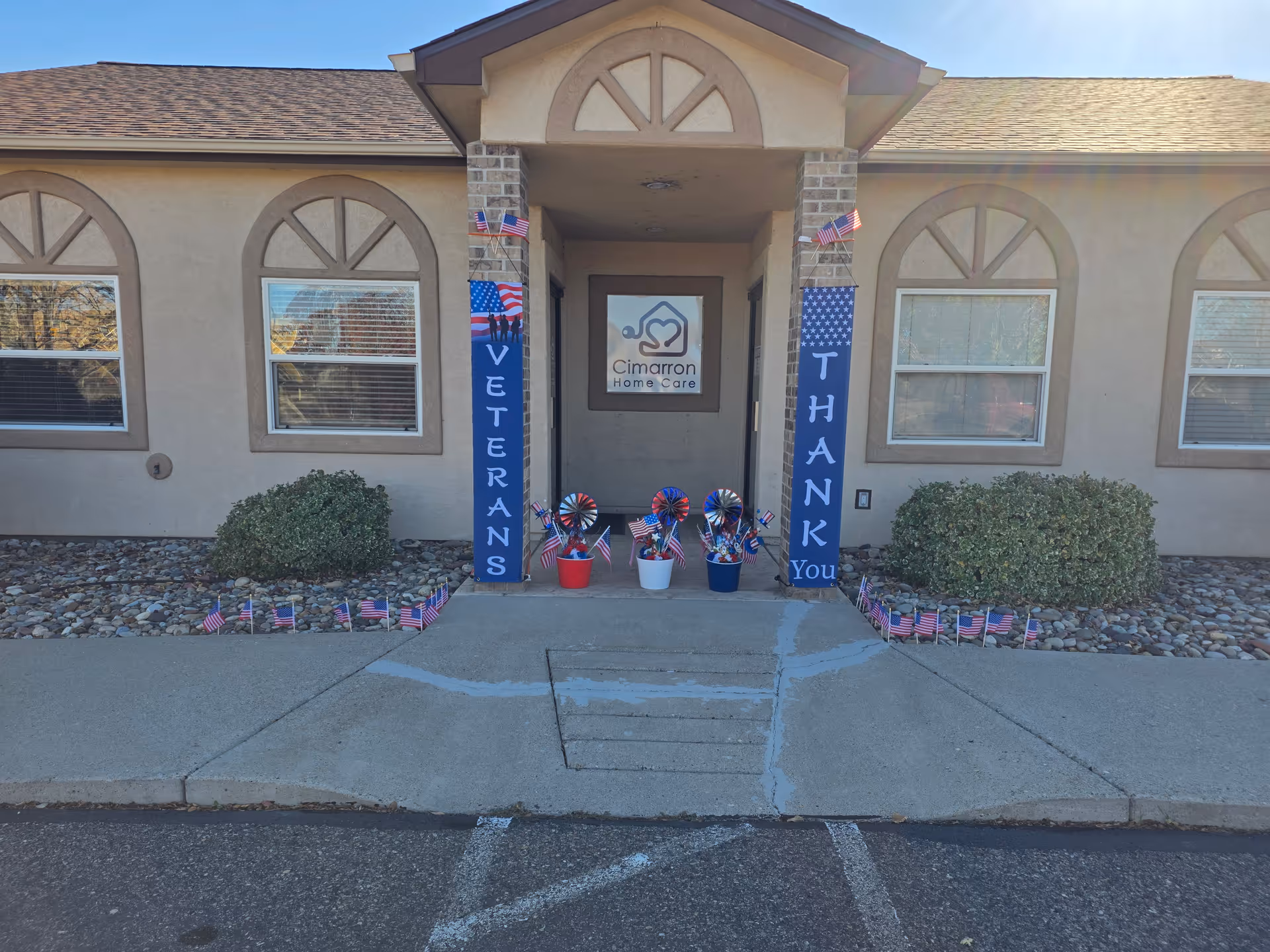 Front entrance of Cimarron Home Care adorned with patriotic banners and small American flags.