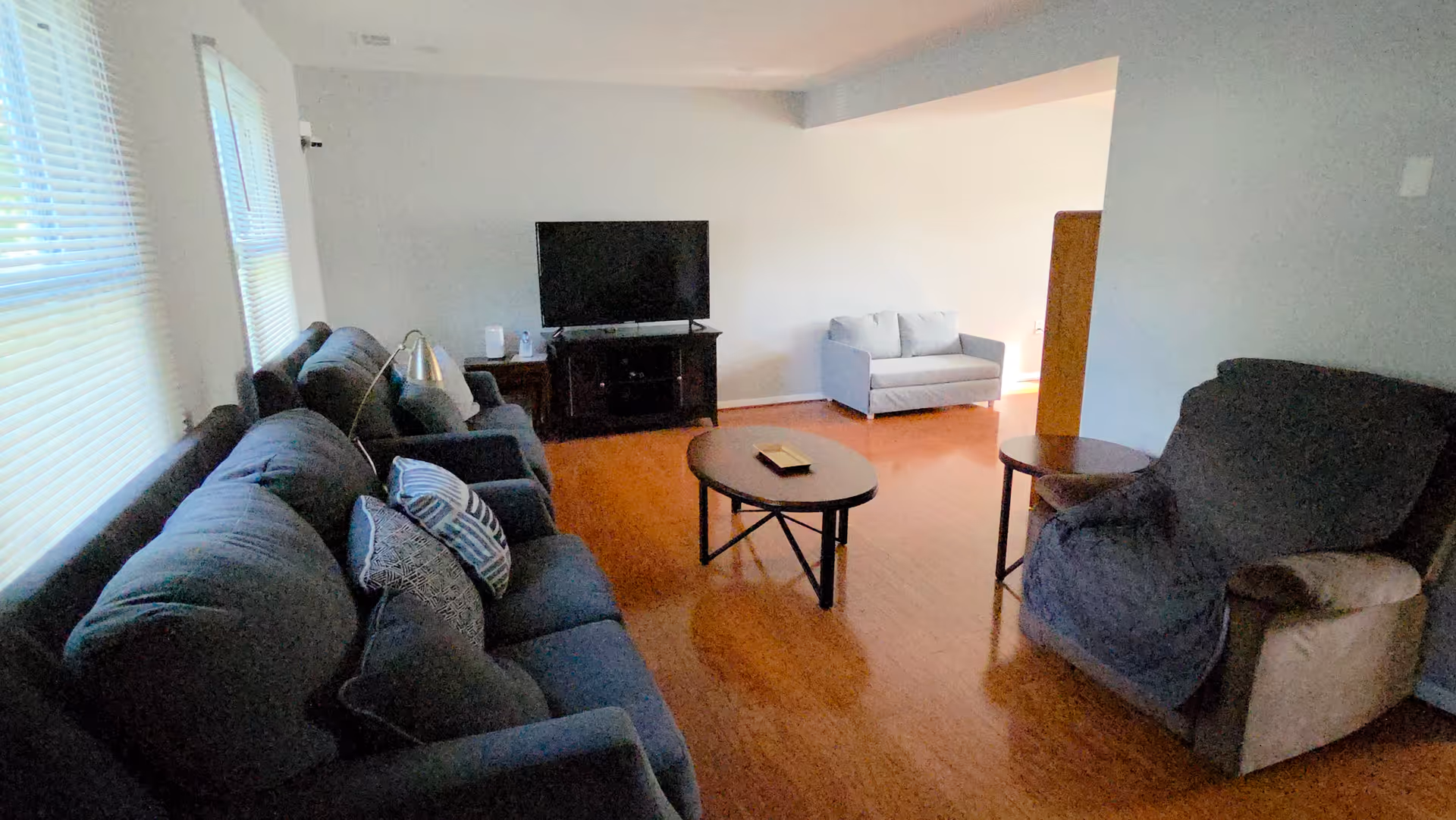 Cozy living room with sofas, chairs, a coffee table, and a television.