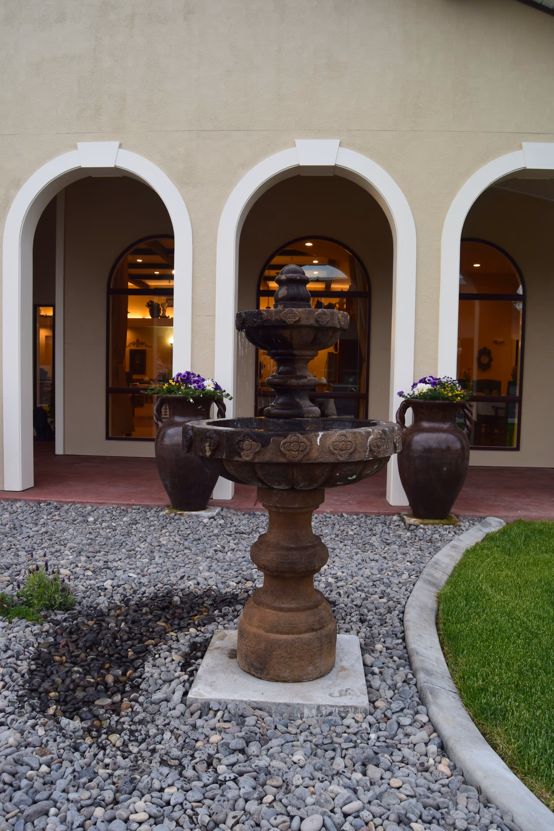 Exterior view of Guardian Angel Homes with arched doorways and a central fountain.