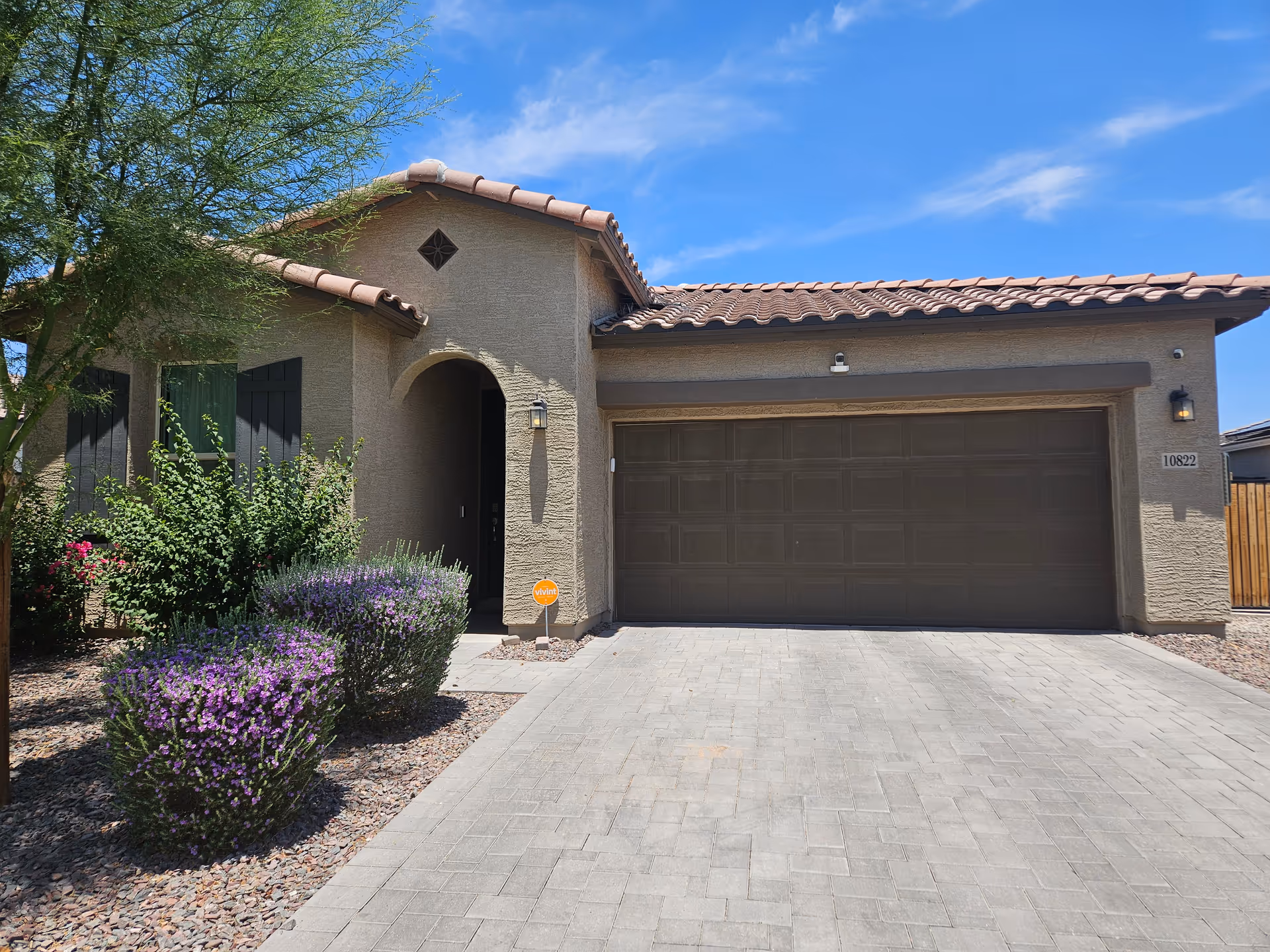 Front exterior view of Primavera Assisted Living facility with a two-car garage and landscaped yard