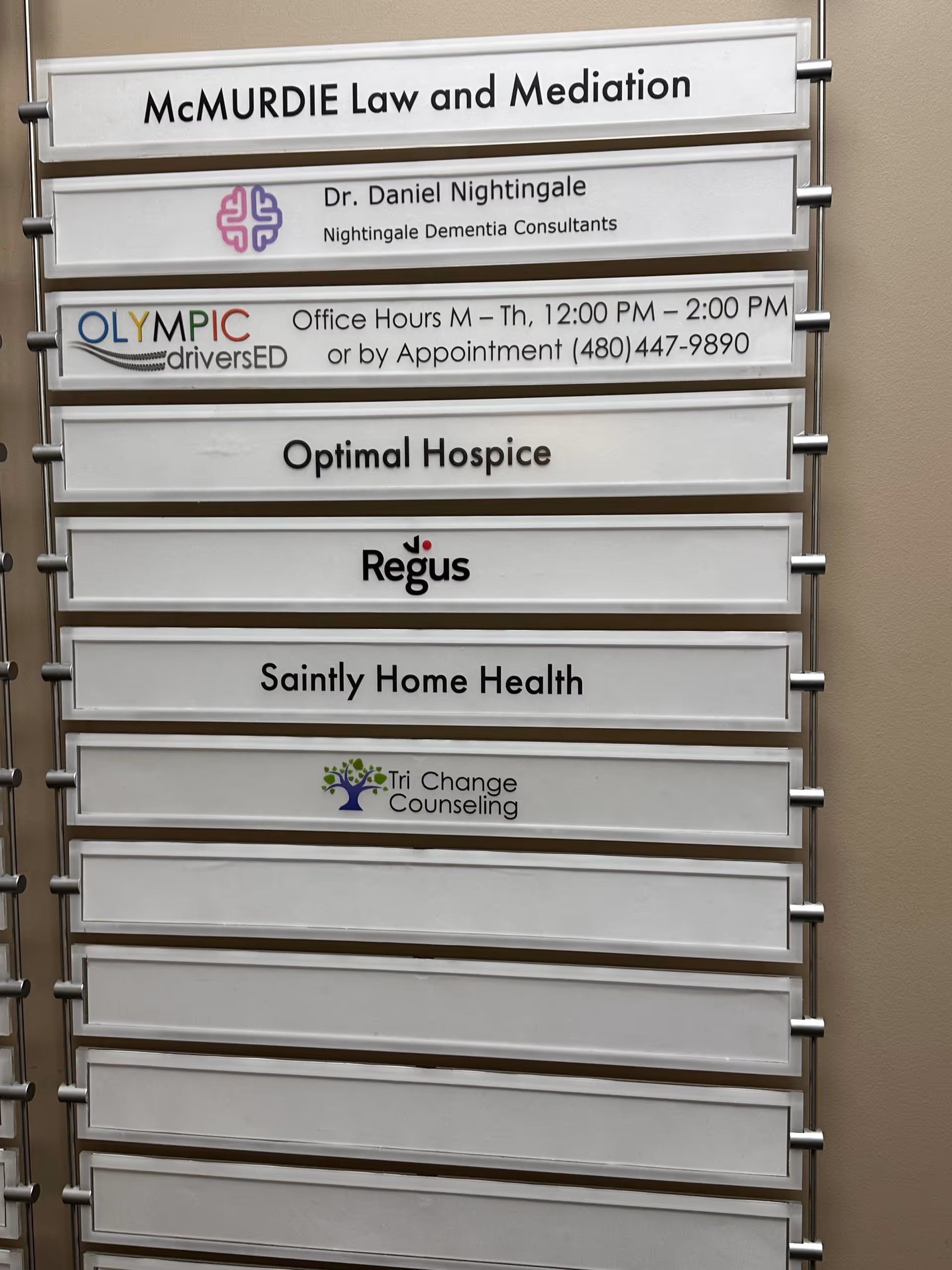 Outdoor directory sign displaying multiple business names, including Saintly Home Health.