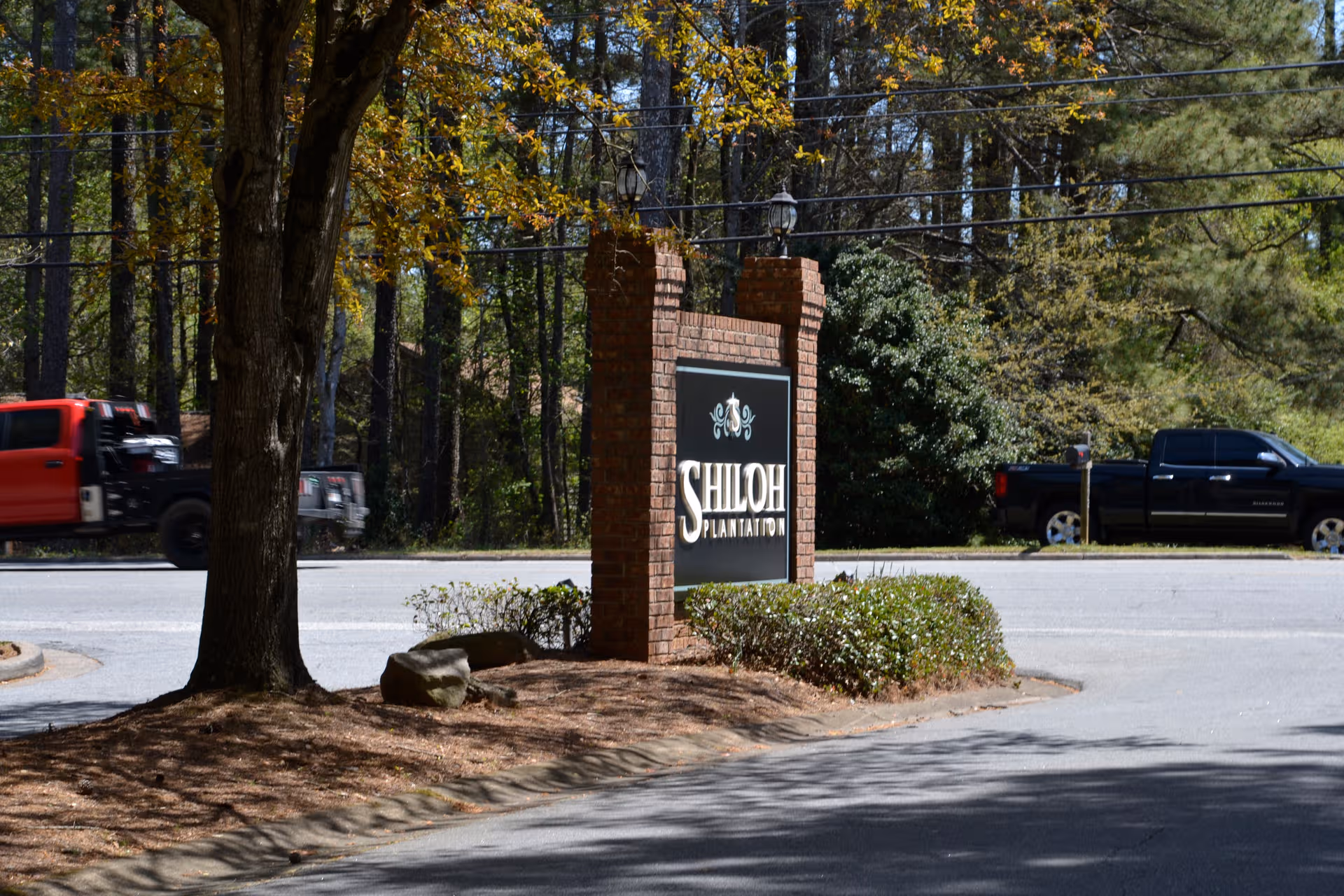 Exterior view of Shiloh Place sign at the facility entrance with cars nearby.