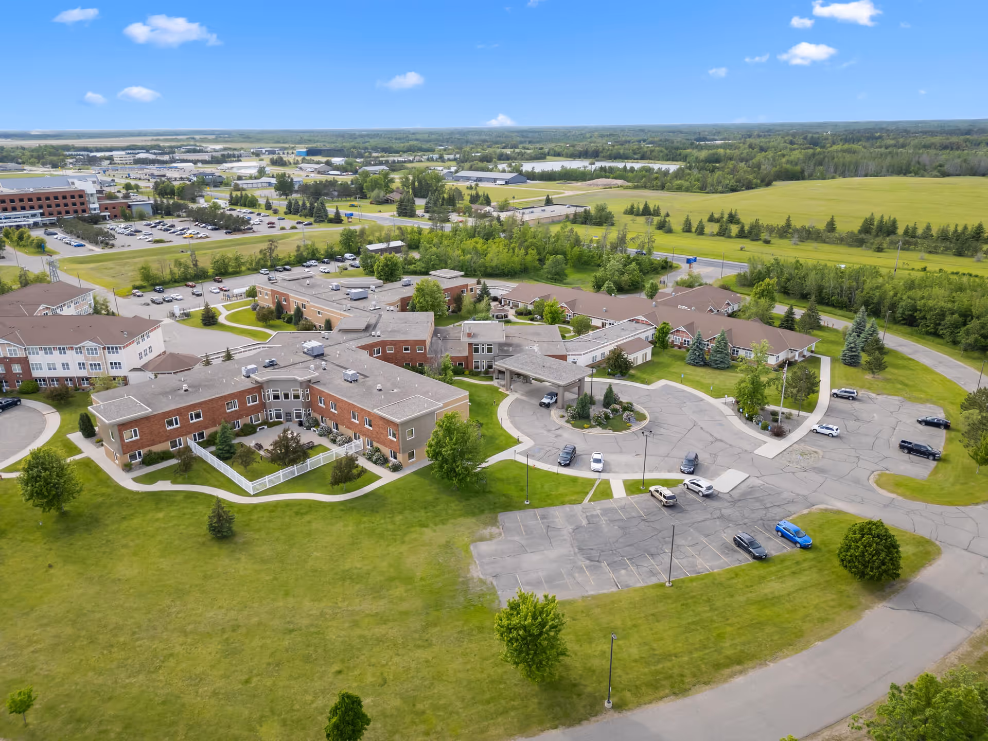 Aerial view of Neilson Place campus with brick buildings, parking lots, and green lawns.