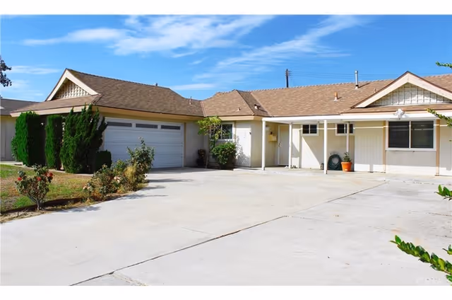 Single-story senior care facility exterior with a wide driveway, garage, and front entrance.