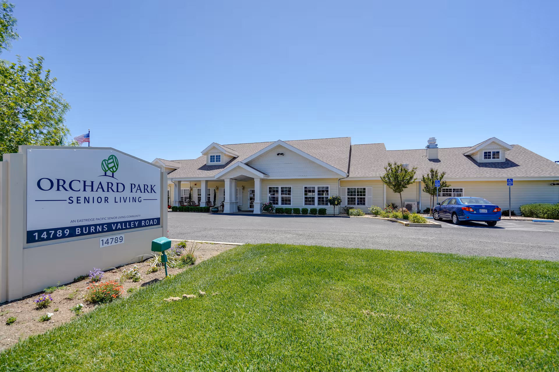 Exterior view of Orchard Park Senior Living Community with a sign and entrance.