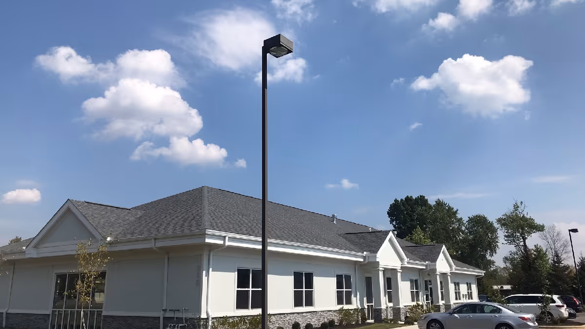 Single-story white facility exterior with a gabled roof and cars parked outside.