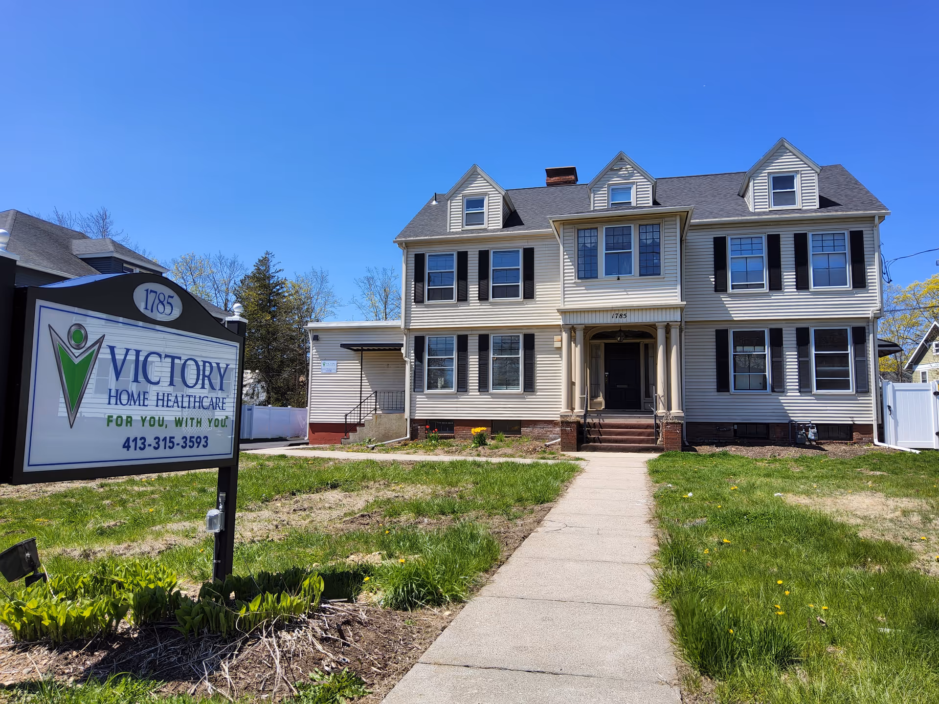Front exterior view of a two-story building with a Victory Home Healthcare sign outside.