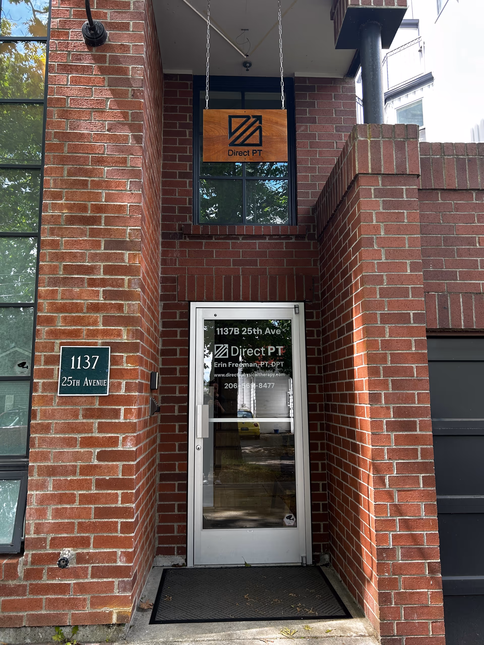 Brick building entrance with Direct PT sign and glass door.