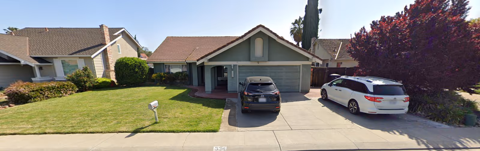 Front exterior view of Gavero's Care Home, a single-story building with a driveway and two cars.