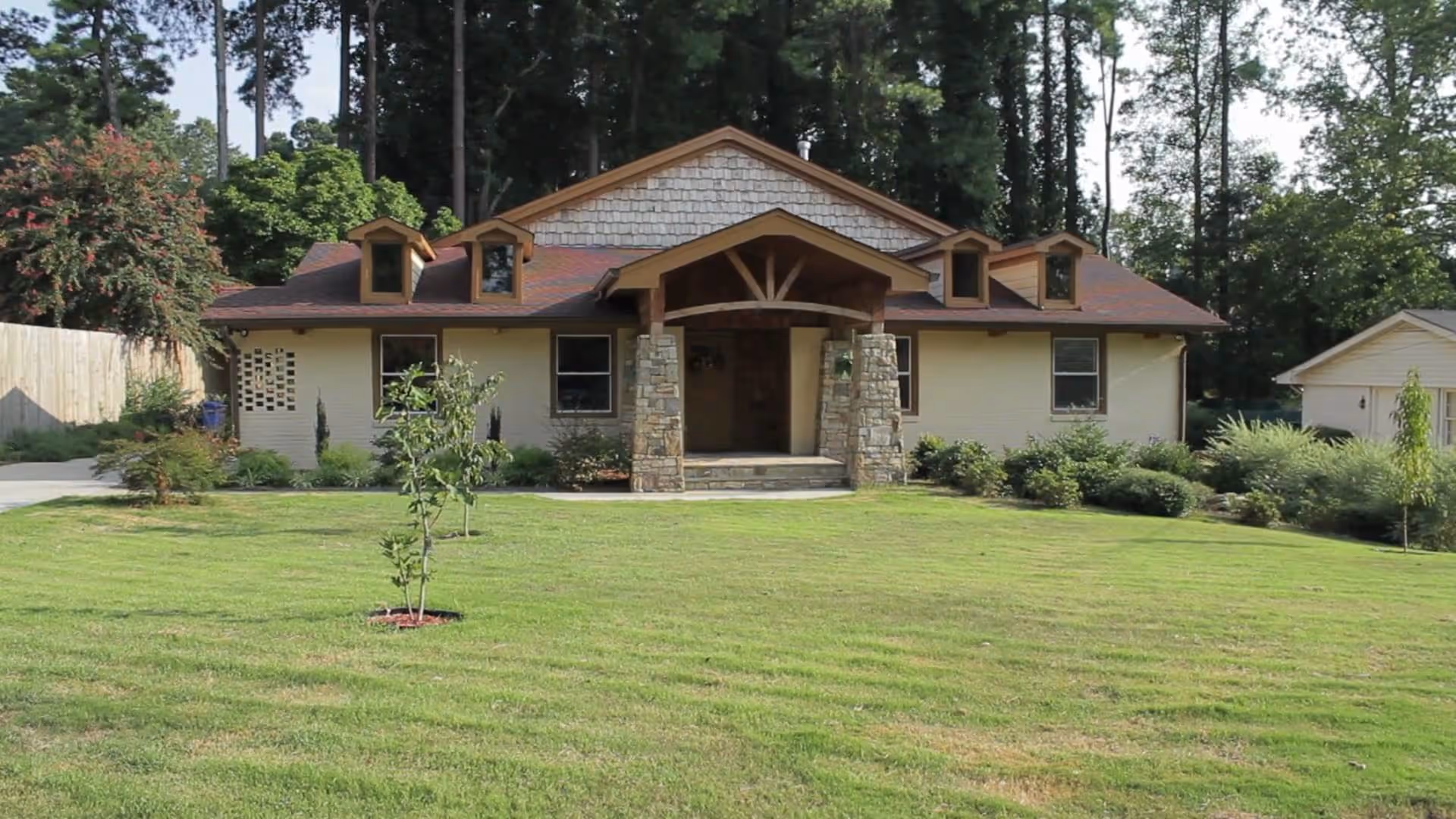 Single-story senior living facility with stone columns and a manicured front lawn.