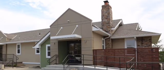 Front exterior view of a senior living facility featuring a ramped entrance.
