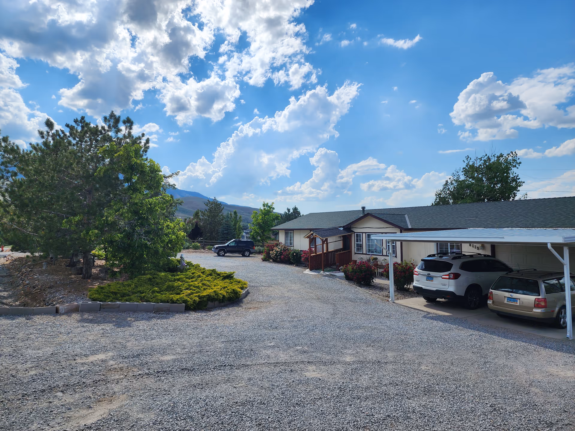 Exterior view of a single-story Horizon Hills Residential building with gravel driveway and parked cars.
