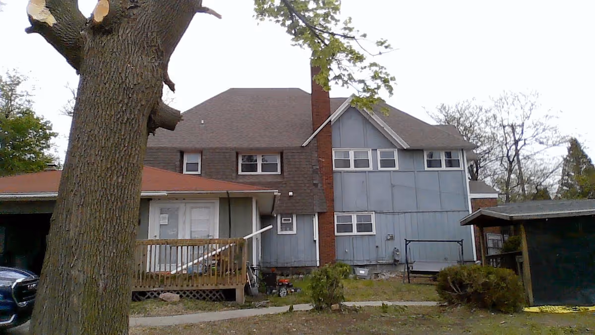 Blue Gibbs Place senior living building with a brick chimney and wooden porch.