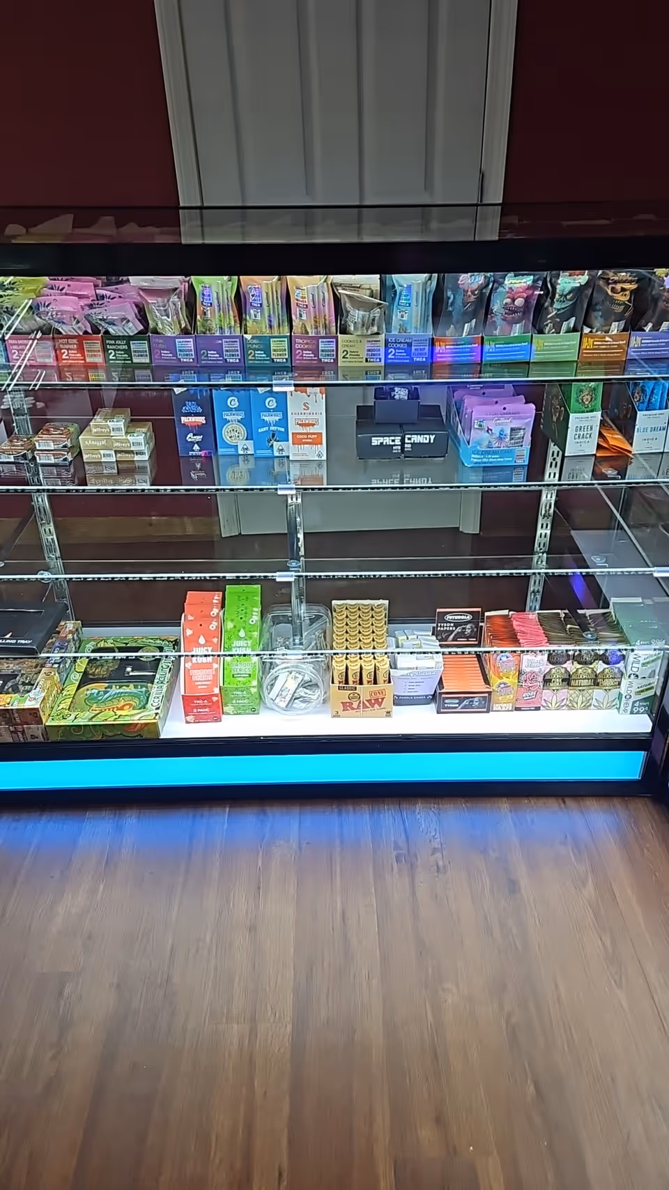 Glass-front refrigerated display case stocked with chocolates and snacks in a senior living facility