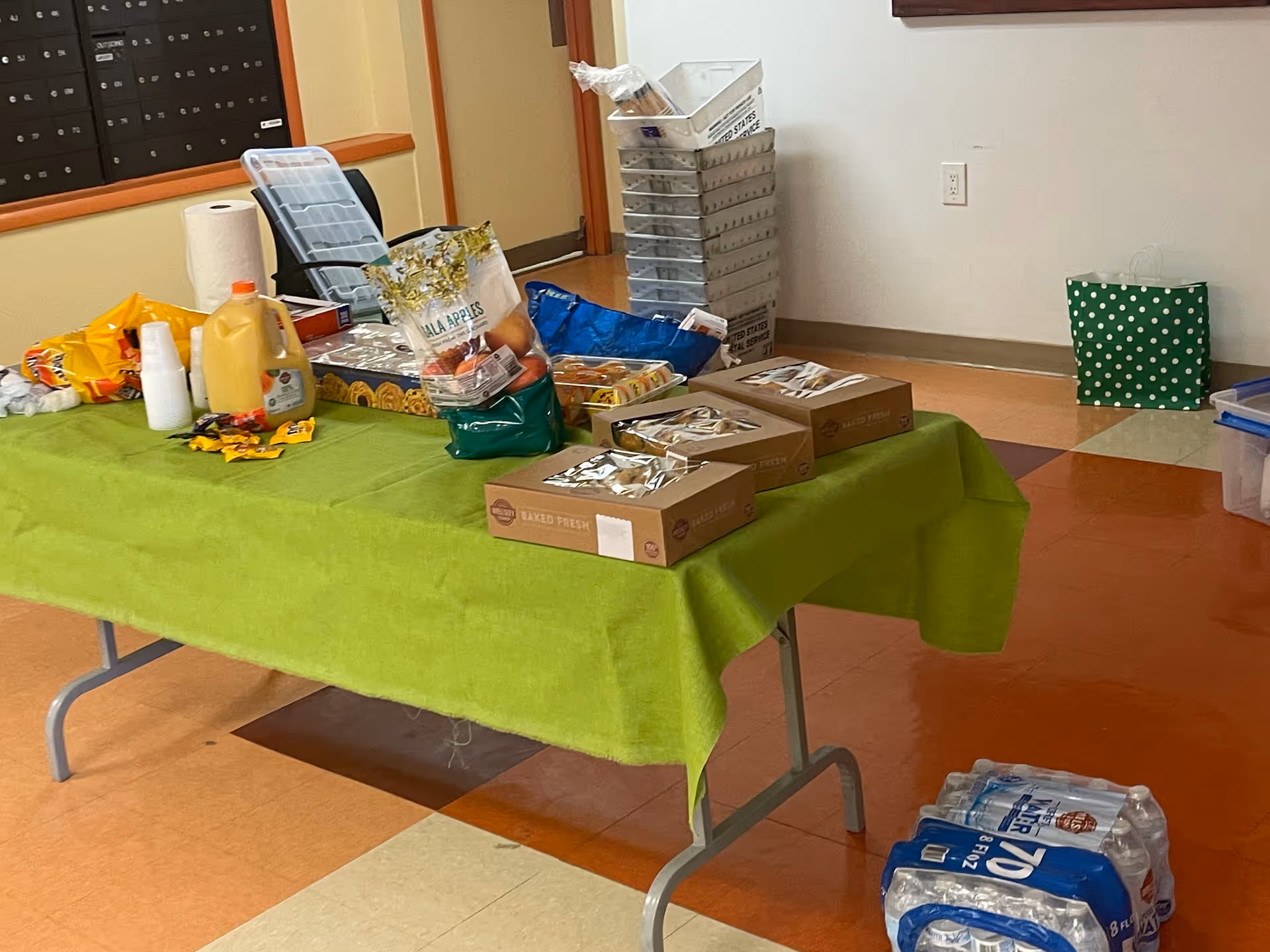 A donation table with groceries and supplies inside a senior living facility.