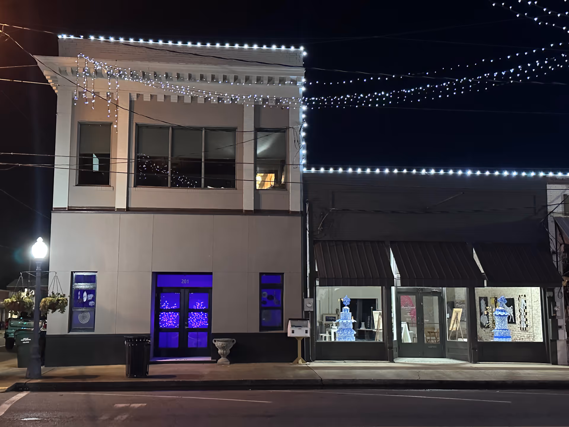 Night view of a two-story building exterior with string lights along the façade.