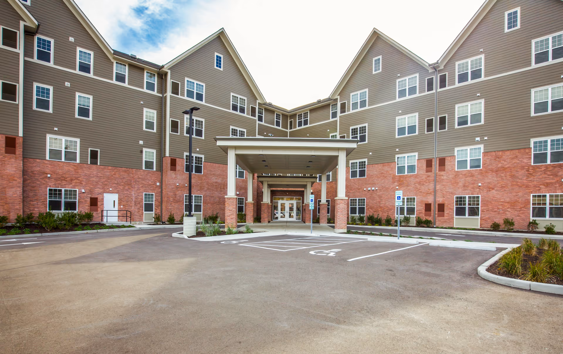 Exterior view of Kingsland Walk Senior Living building with a covered entrance.