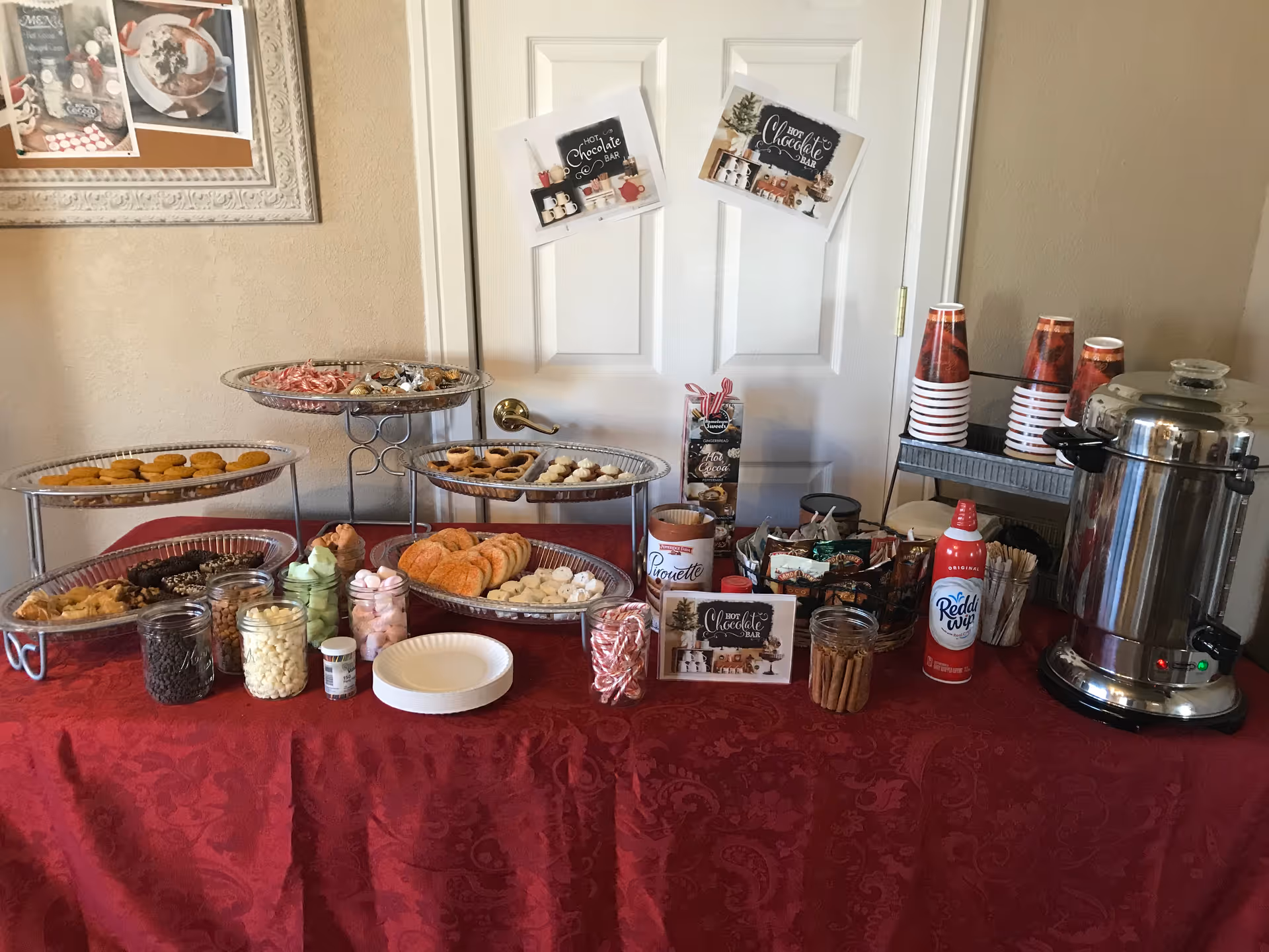 Buffet table with cookies, pastries, candies, drinks, and a coffee urn in a senior home.