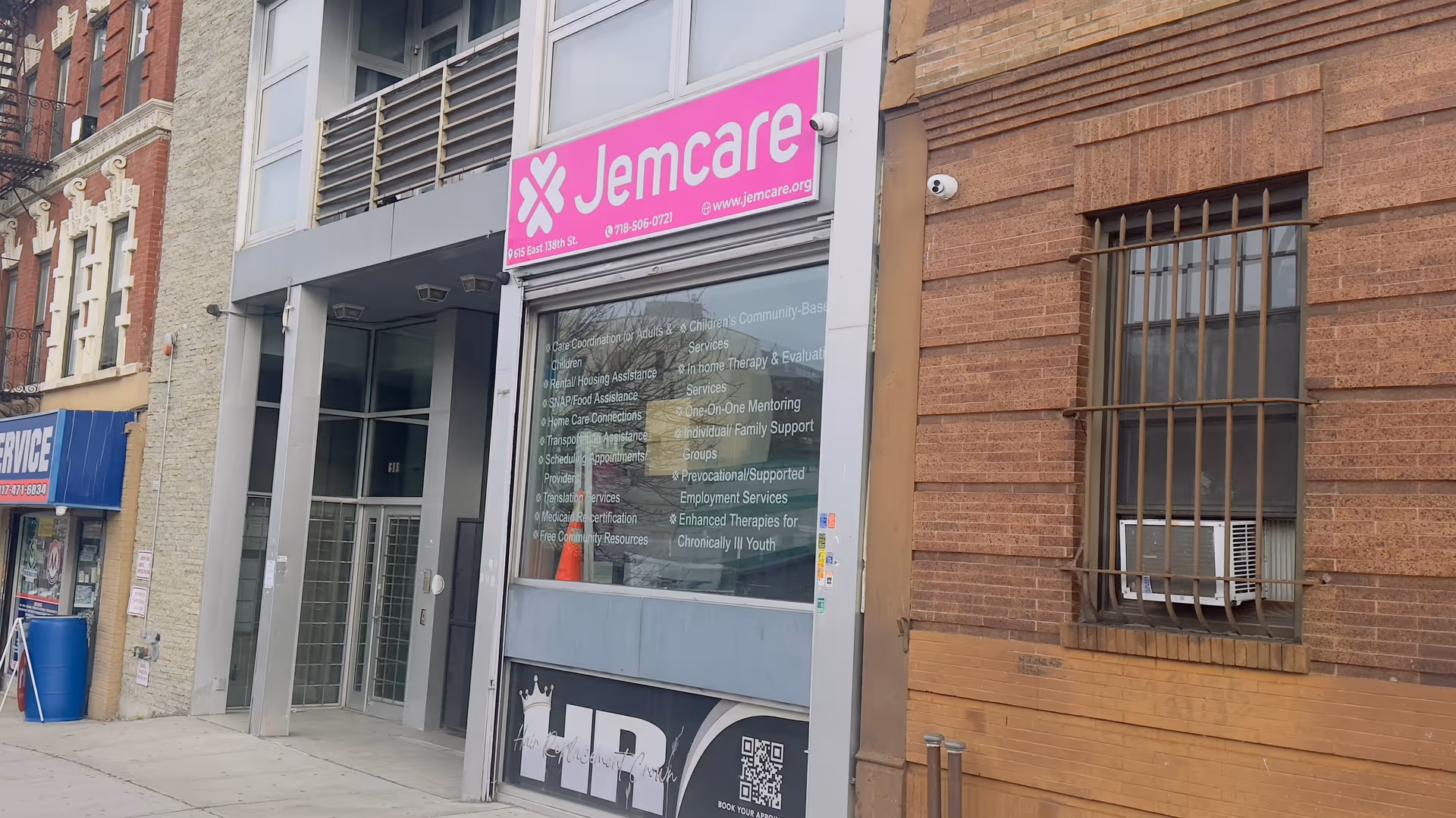 The Jemcare storefront on a city street with a pink sign and glass entrance.