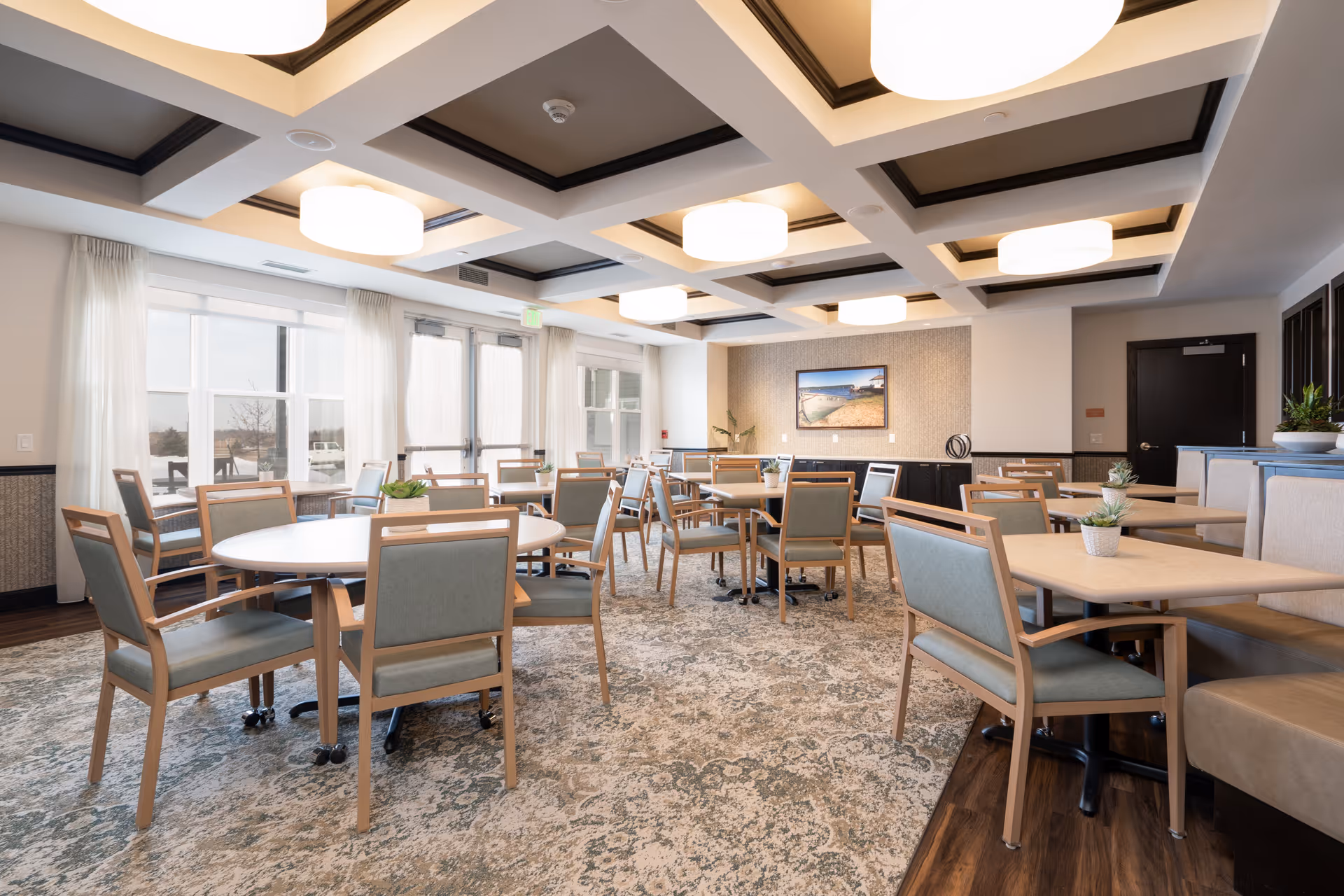 Bright, spacious dining room with tables, chairs, and large windows.