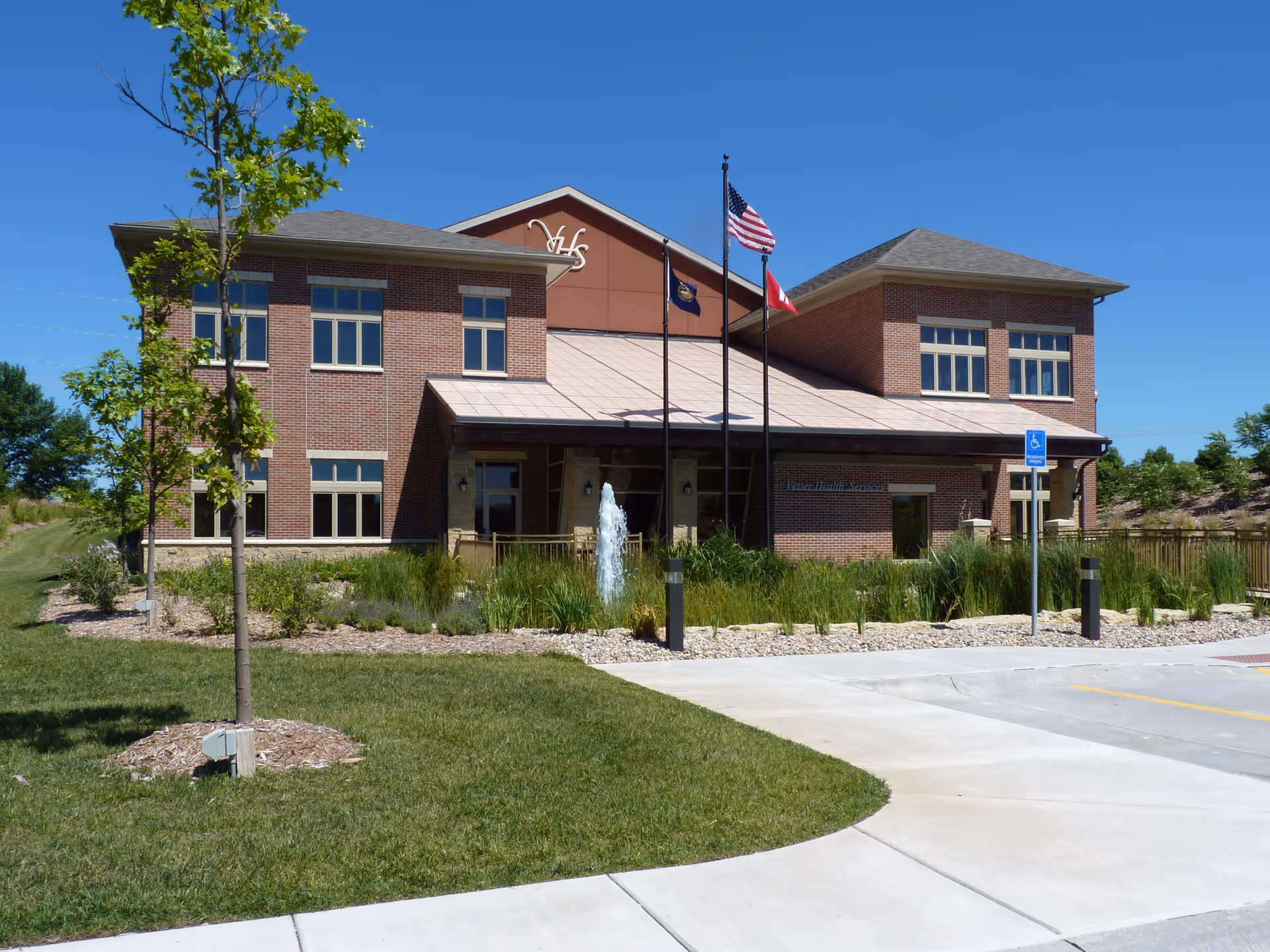 Vetter Senior Living exterior: brick facility front with flags, landscaping, and a fountain.