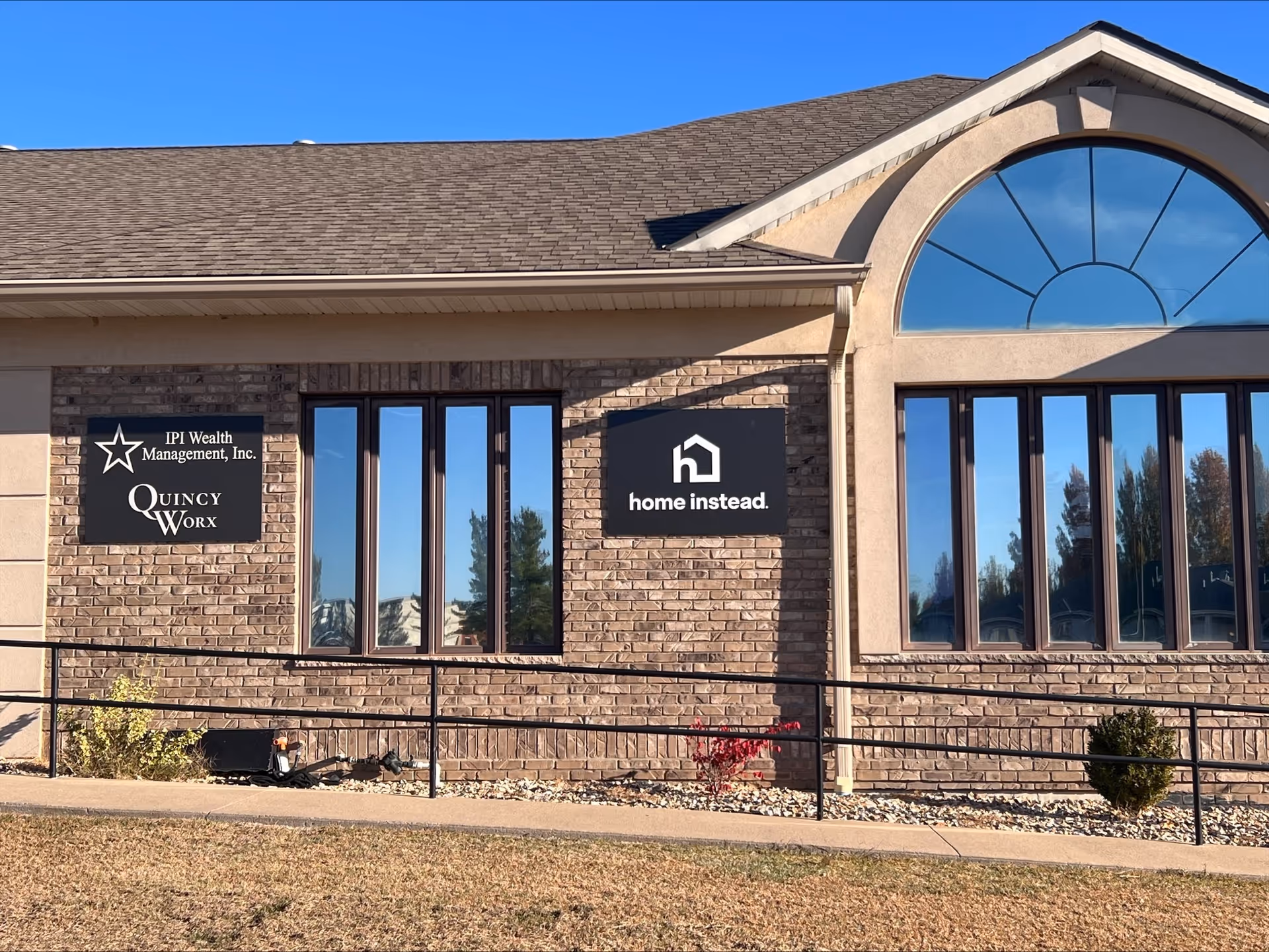 Exterior view of a brick building with Home Instead sign and arched window