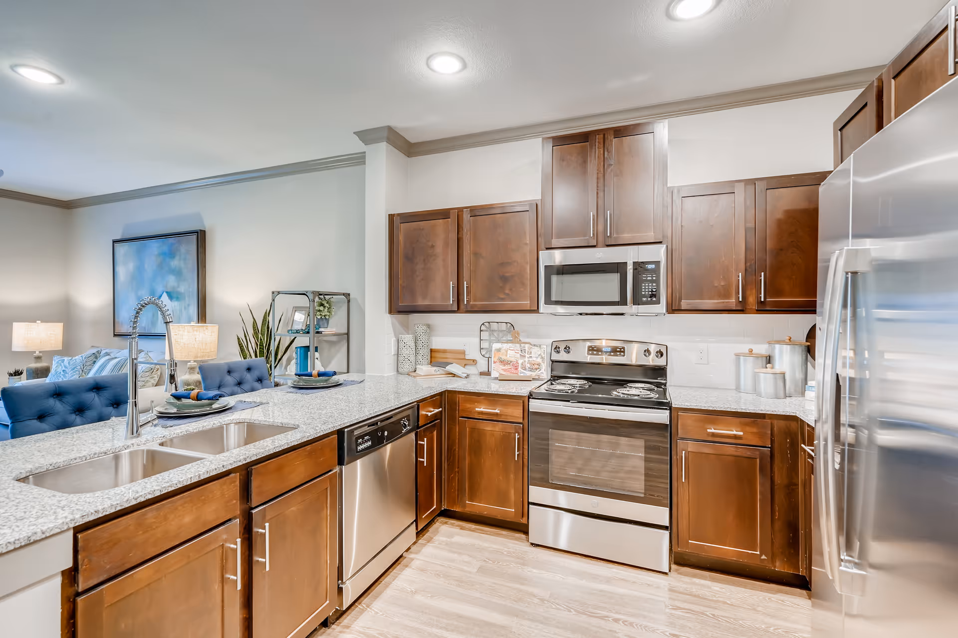Modern kitchen with dark wood cabinets, stainless steel appliances, and a granite island.