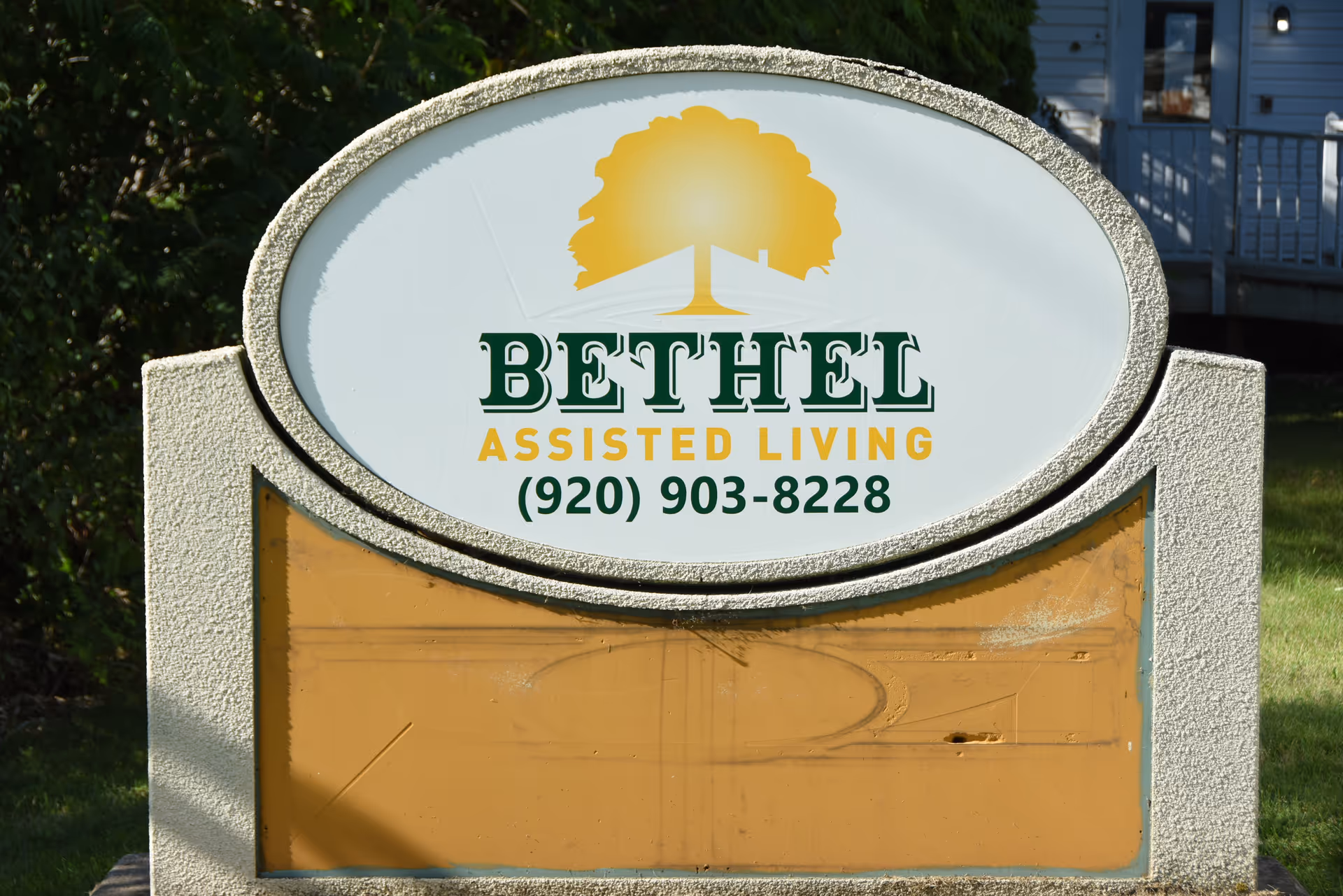Oval Bethel Assisted Living sign with tree logo and building in background