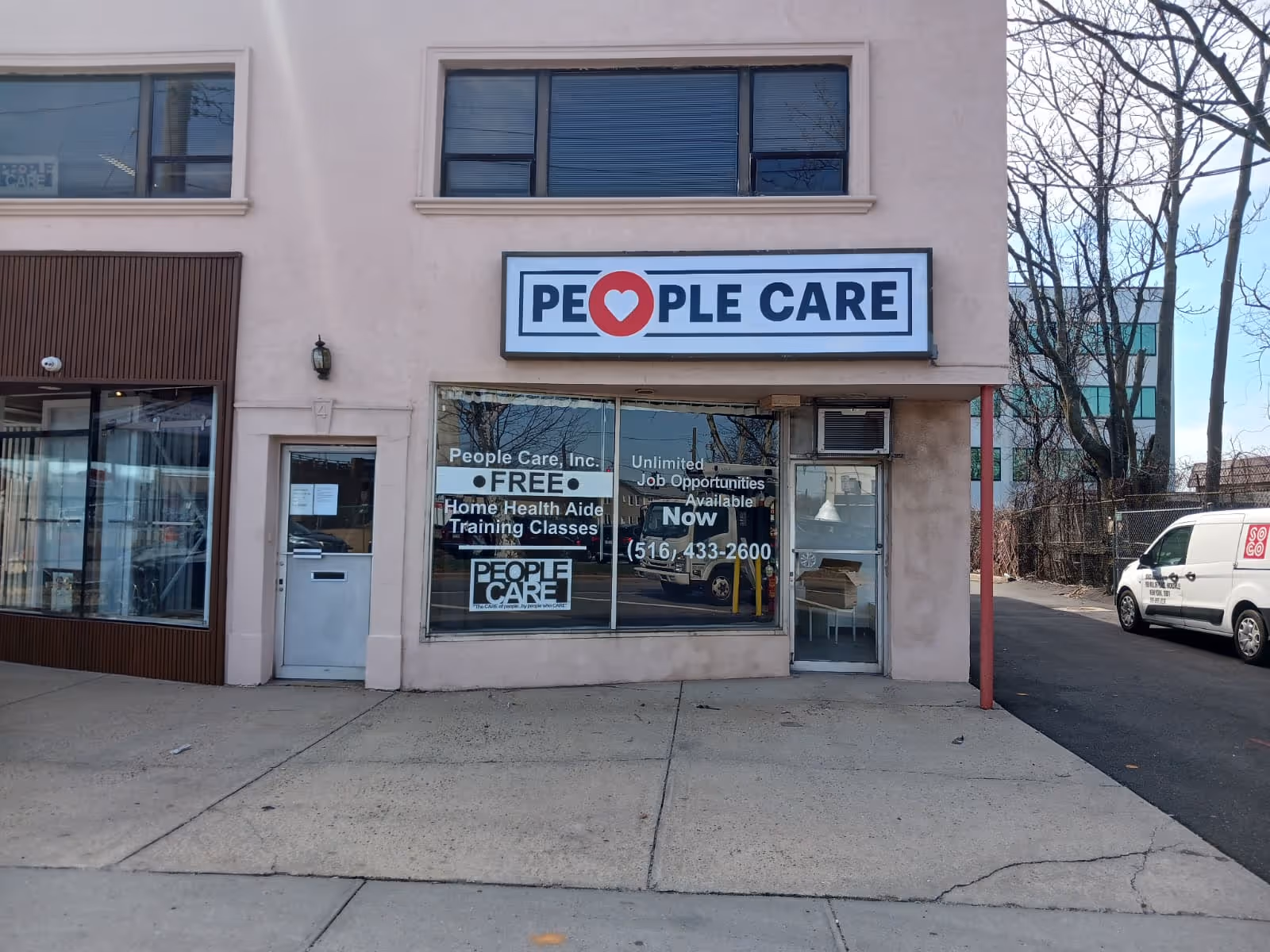Exterior of a pink building with a People Care storefront sign