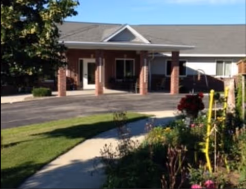 Exterior view of Wayside Parkview Estates entrance with brick columns and a garden in foreground.