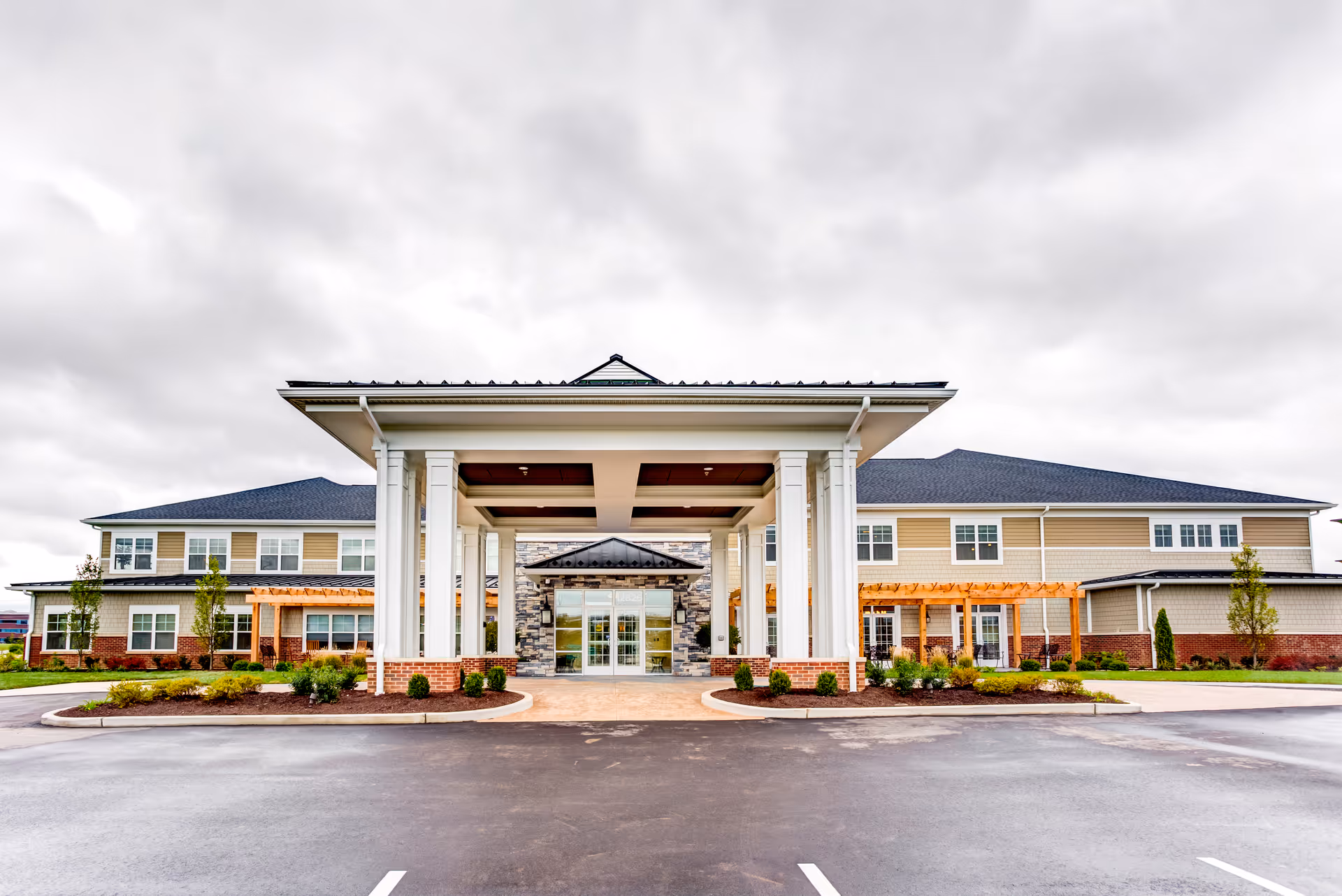 Exterior view of Cedarhurst of Des Peres with a covered entry and parking lot.