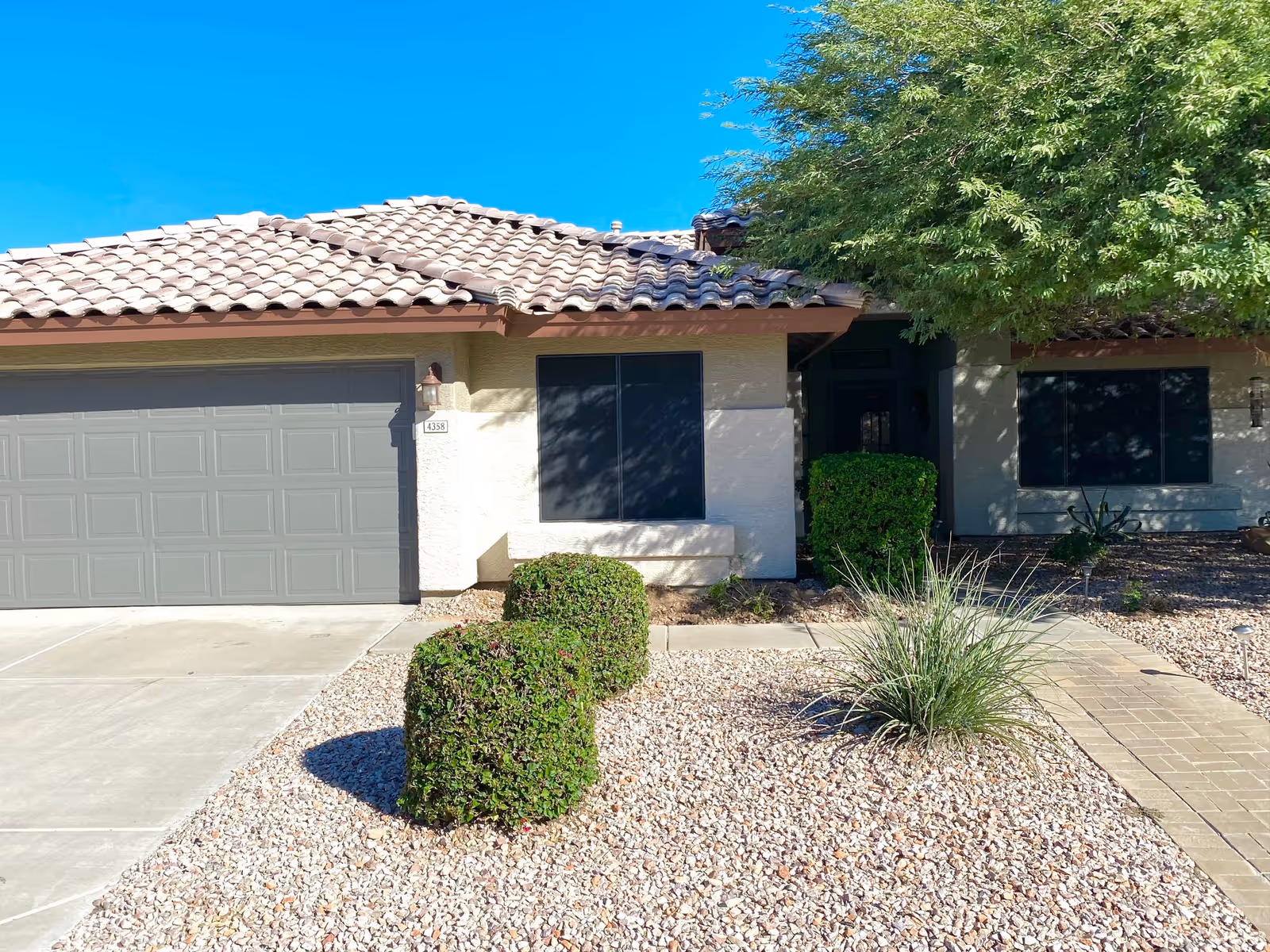 Front exterior of a single-story home with a two-car garage and desert landscaping.