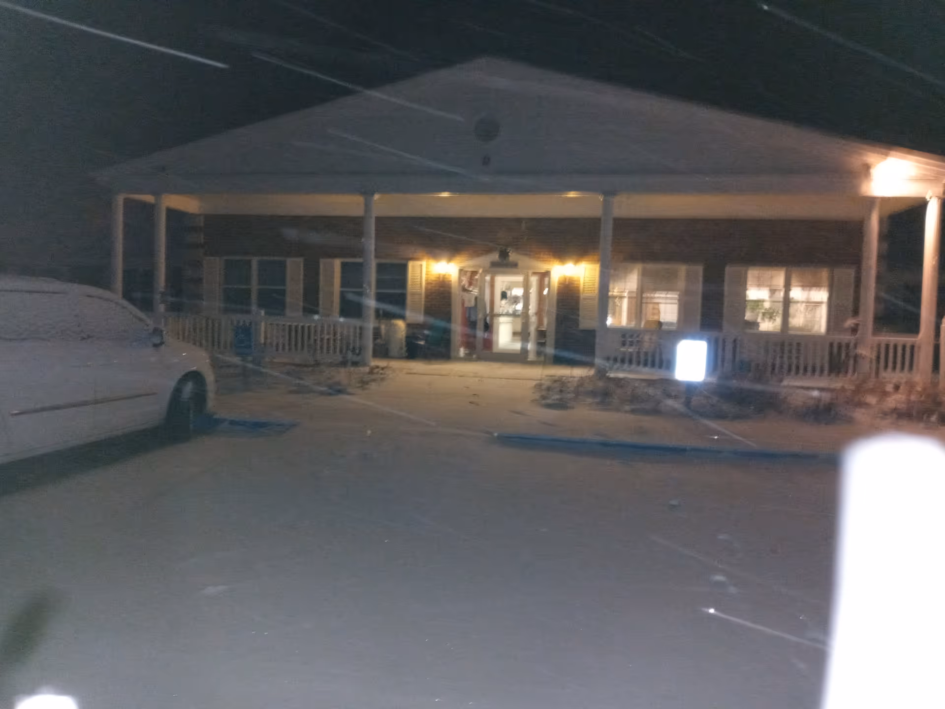 Night exterior of Ponderosa Villa showing a front porch, entrance lights, and a parked van.