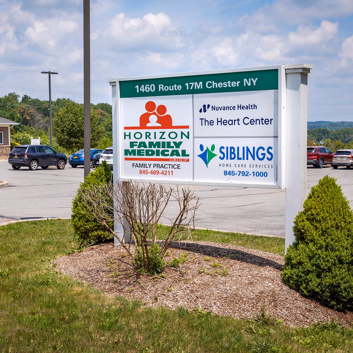 Outdoor sign display for Nuvance Health Heart Center with other medical services in a parking lot.