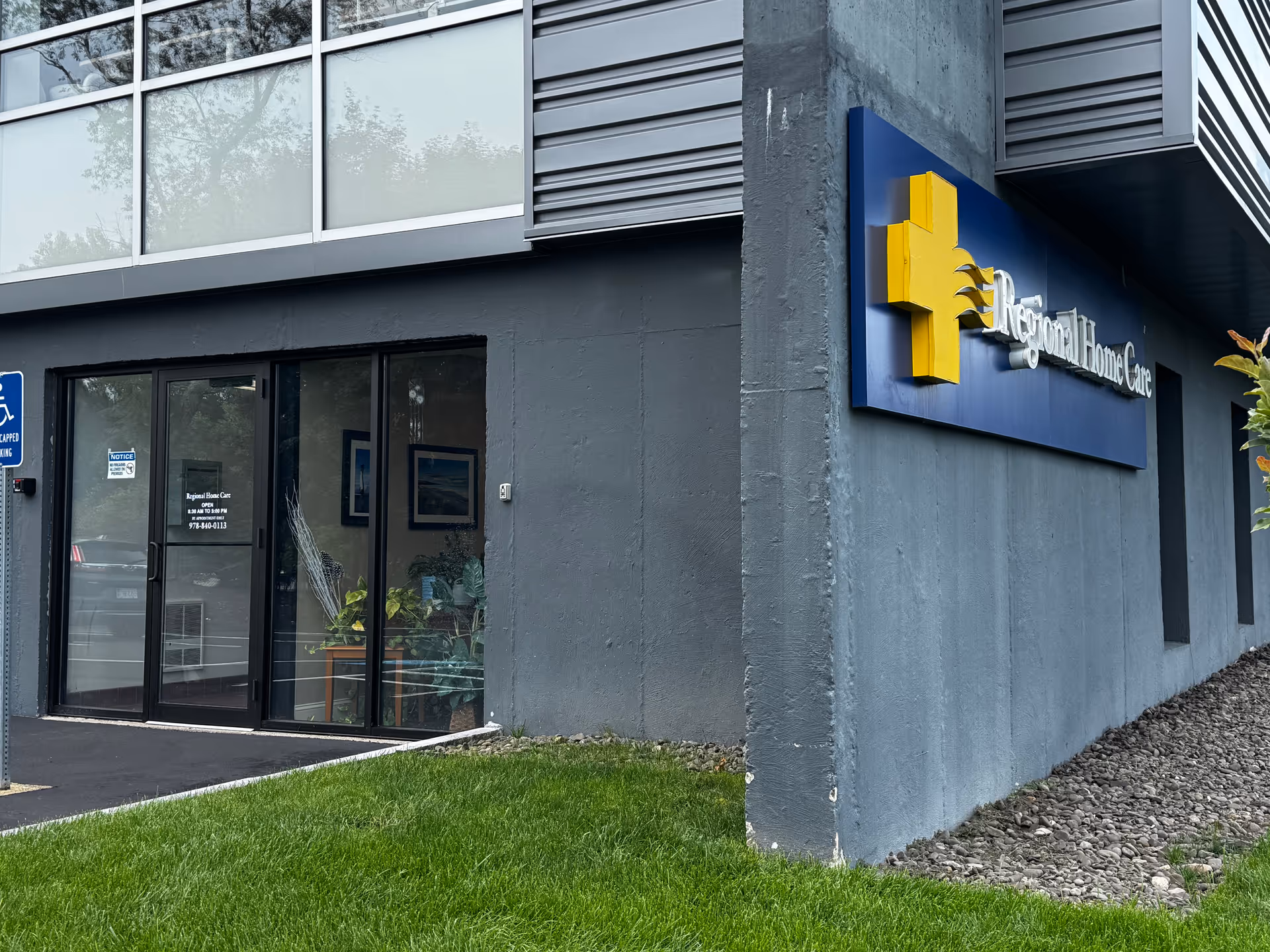 Exterior view of a gray Regional Home Care building with a blue sign and glass entrance.