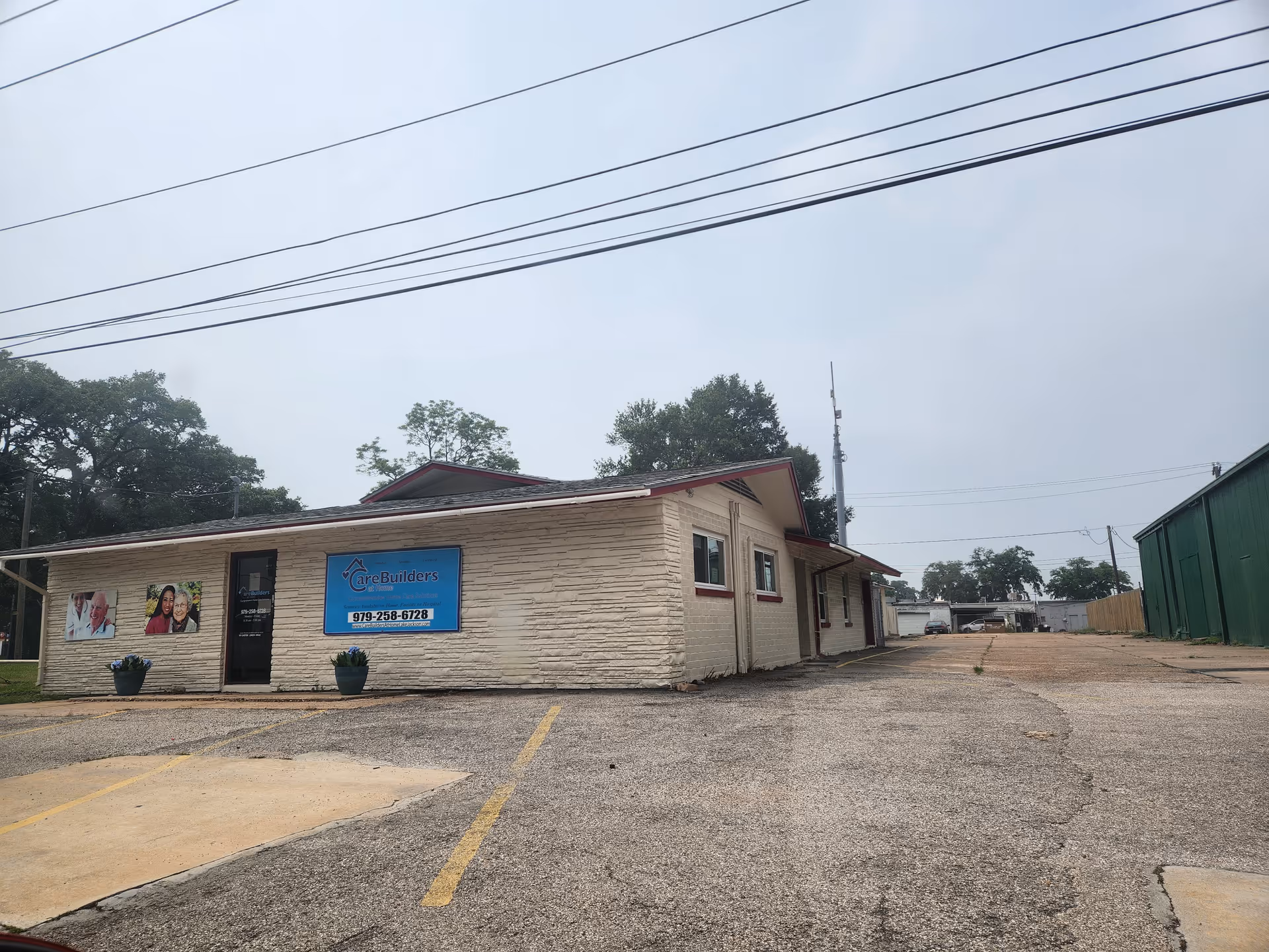 One-story beige building with CareBuilders sign, parking lot, and overhead power lines.
