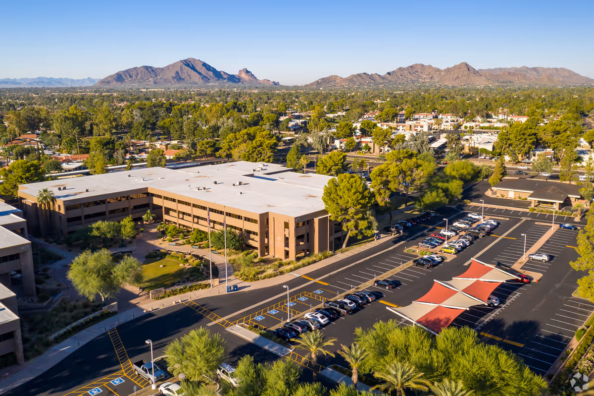 Aerial view of a large senior living campus with parking and red shade canopies